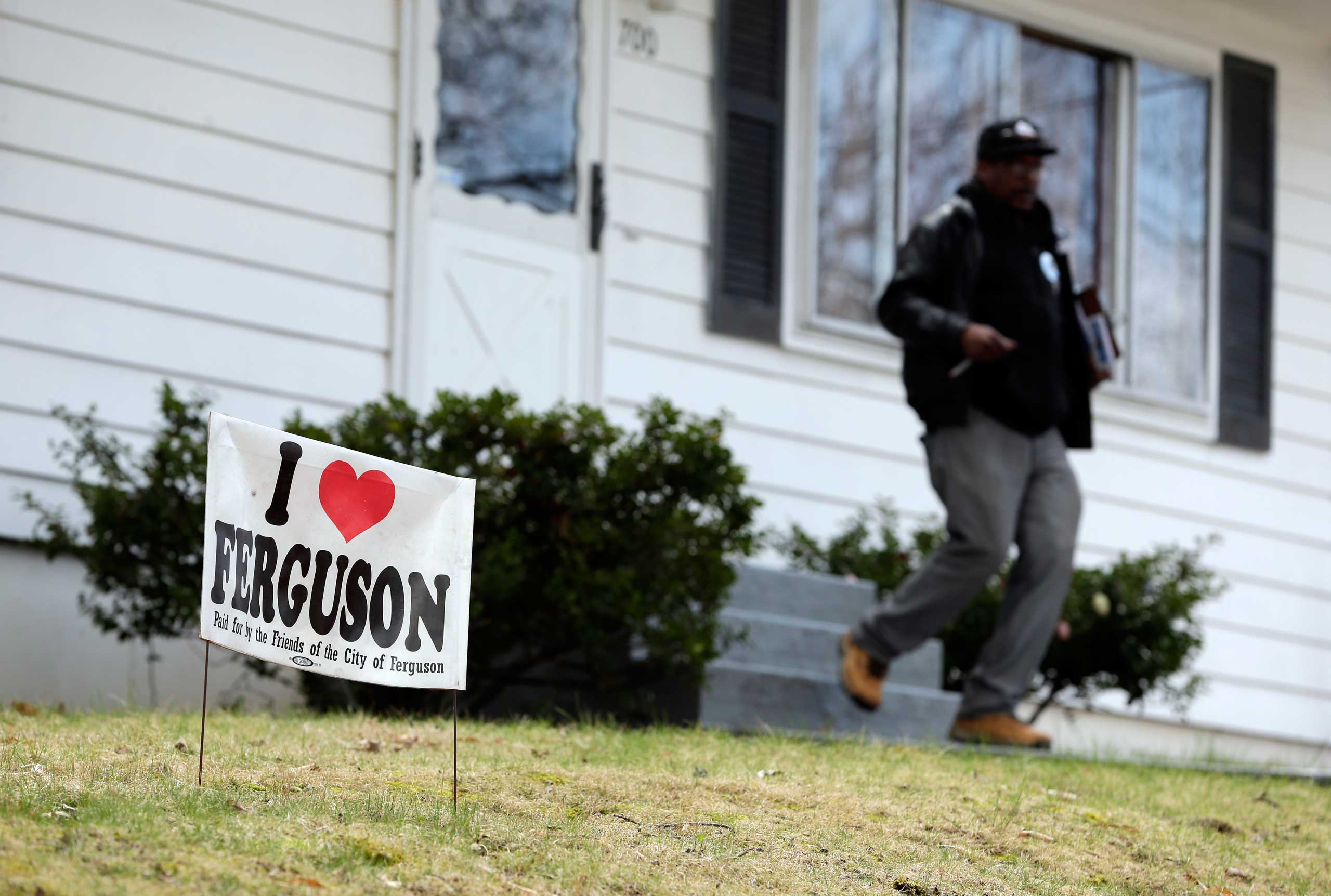 In this photo made Friday, April 3, 2015, Reginald Rounds, a volunteer with the Organization for Black Struggle, walks door-to-door while canvassing a neighborhood in Ferguson, Mo. (Jeff Roberson—AP)