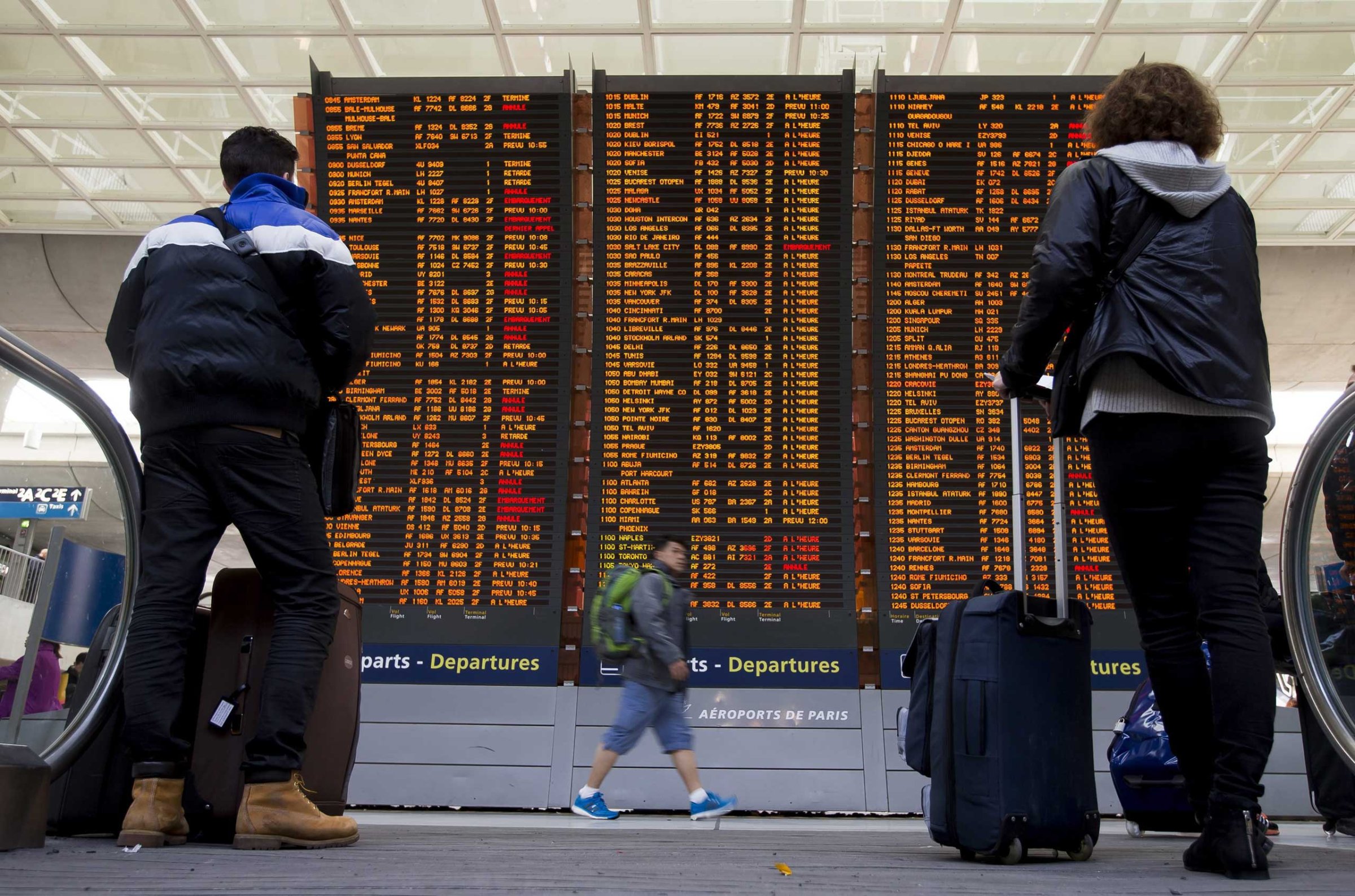 Travellers check a flight information board with various of them listed as 'cancelled' due to a strike of air traffic controllers at the Charles de Gaulle internation airport's terminal 2, in Roissy, near Paris, April 8, 2015.