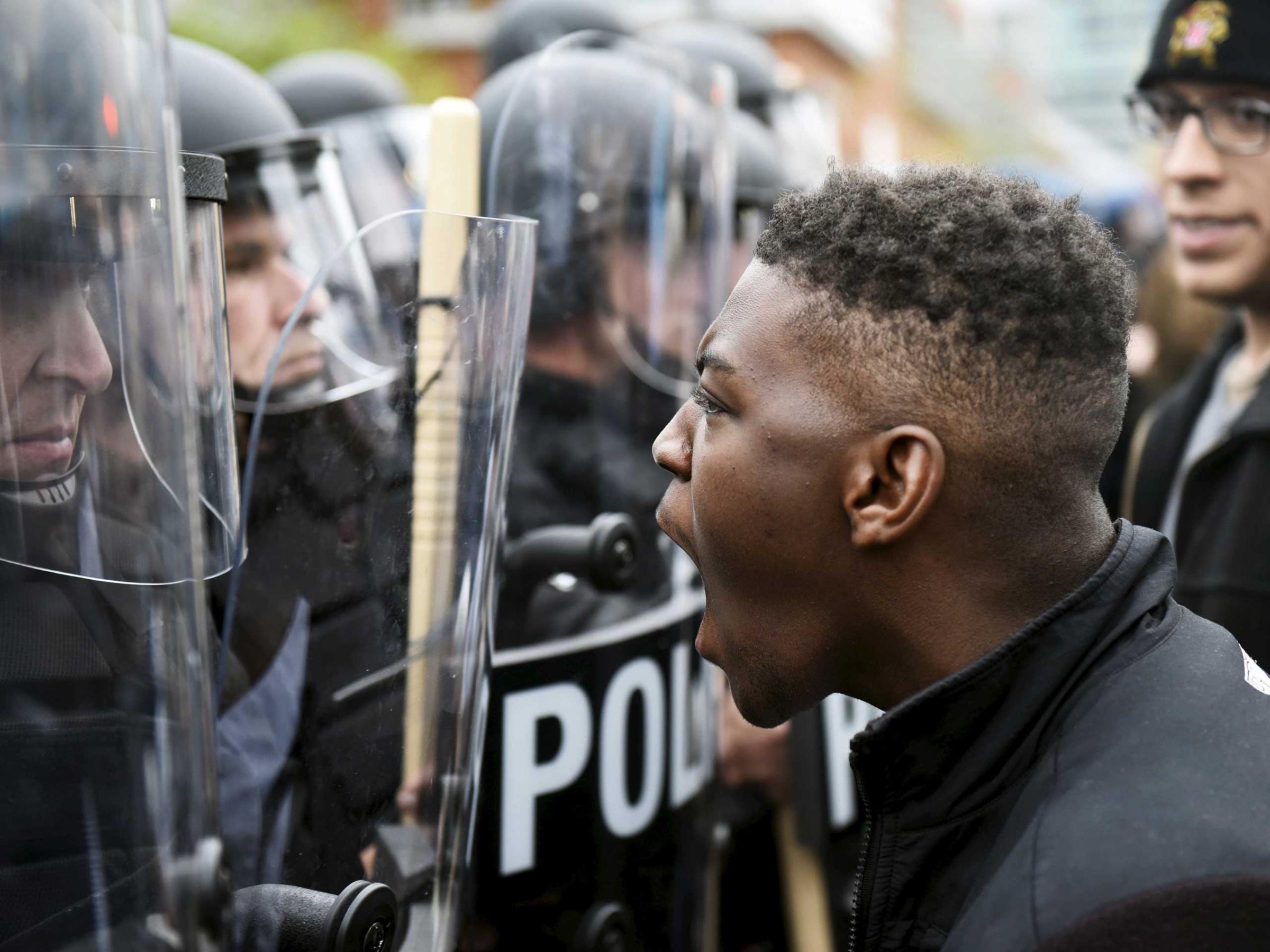 A demonstrator confronts police near Camden Yards during a protest in Baltimore on April 25, 2015.