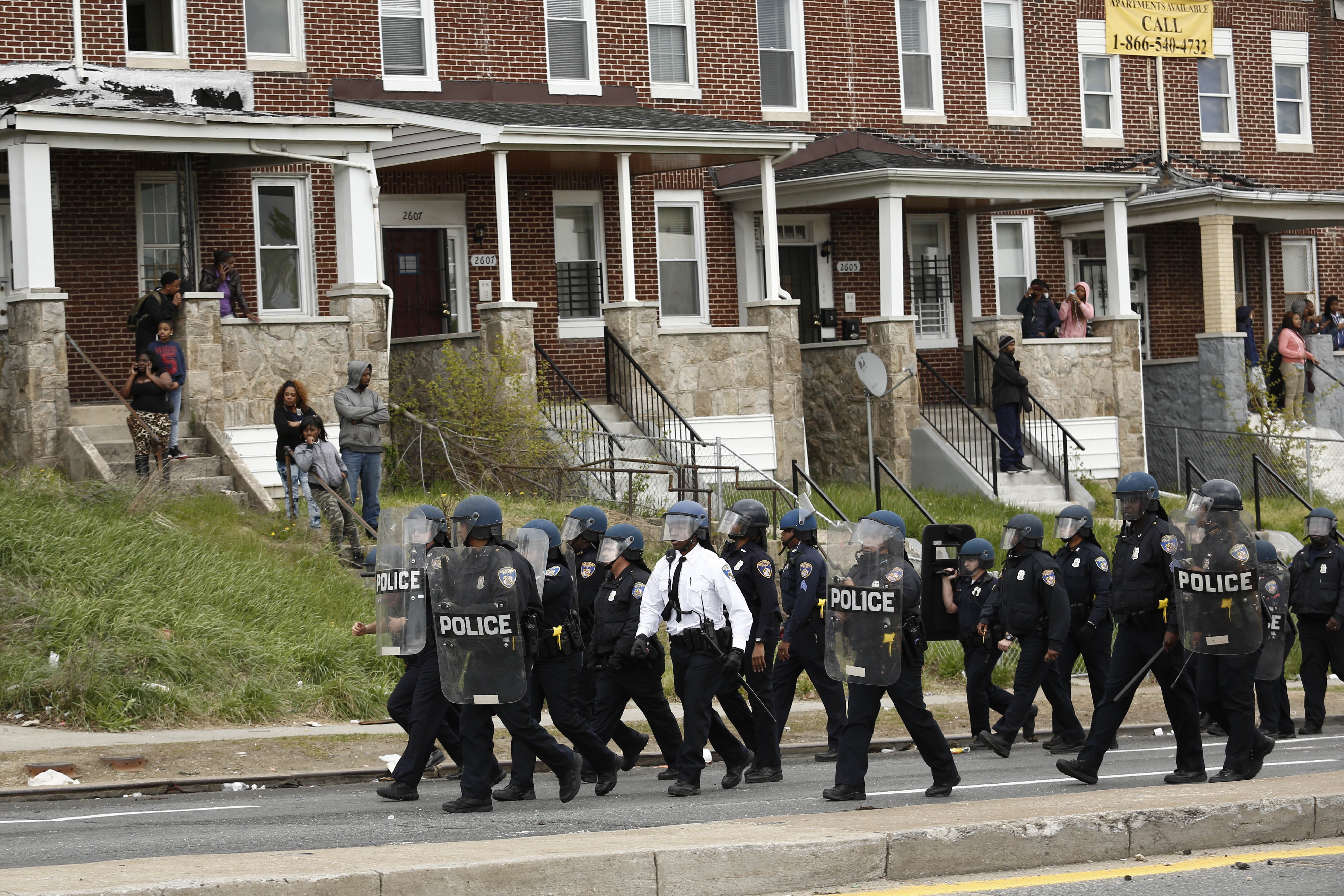 Police officers walk in formation on Reisterstown Road near Mondawmin Mall in Baltimore on April 27, 2015 .