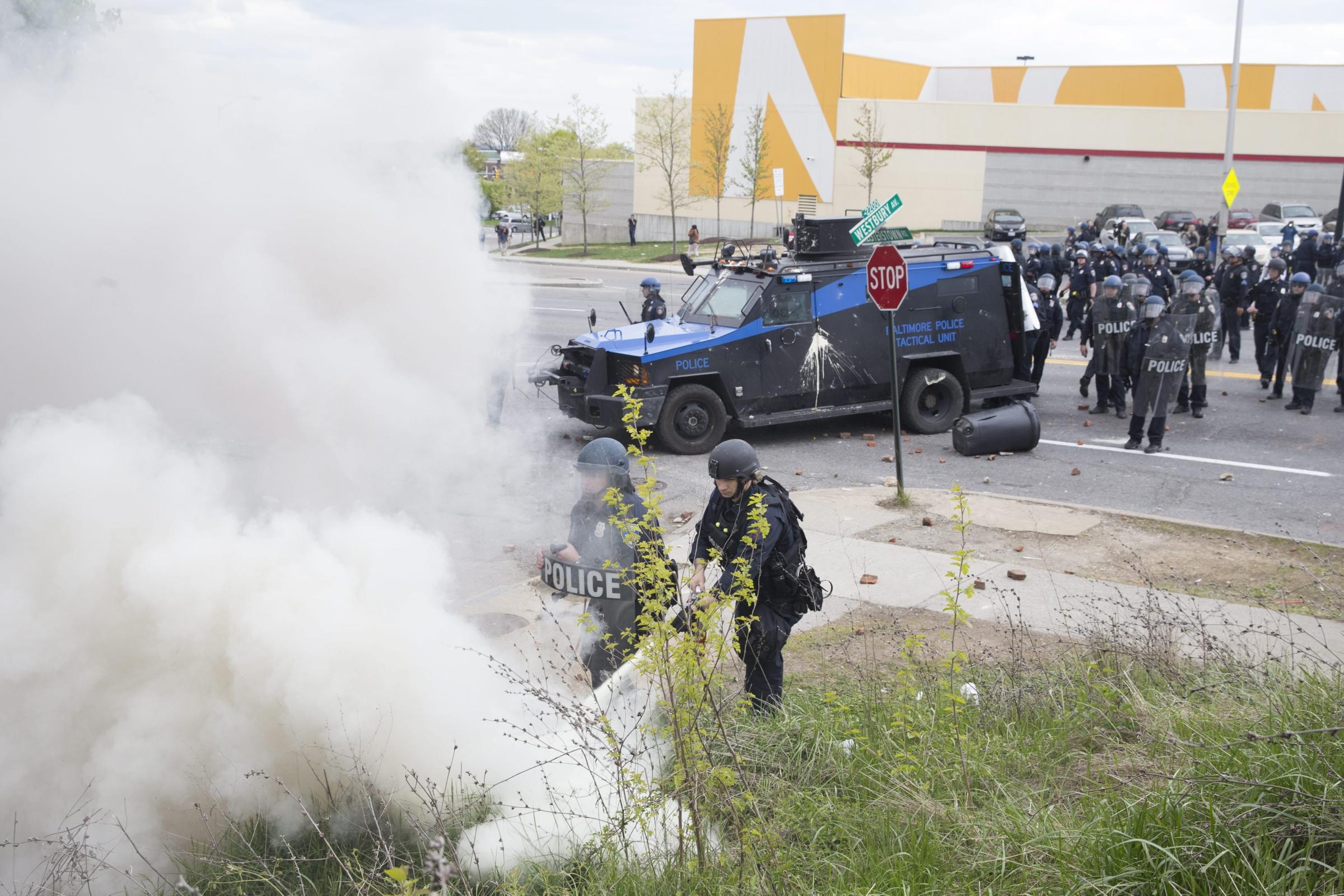 Police put out a fire while responding to people protesting after the funeral of Freddie Gray in Baltimore on April 27, 2015.