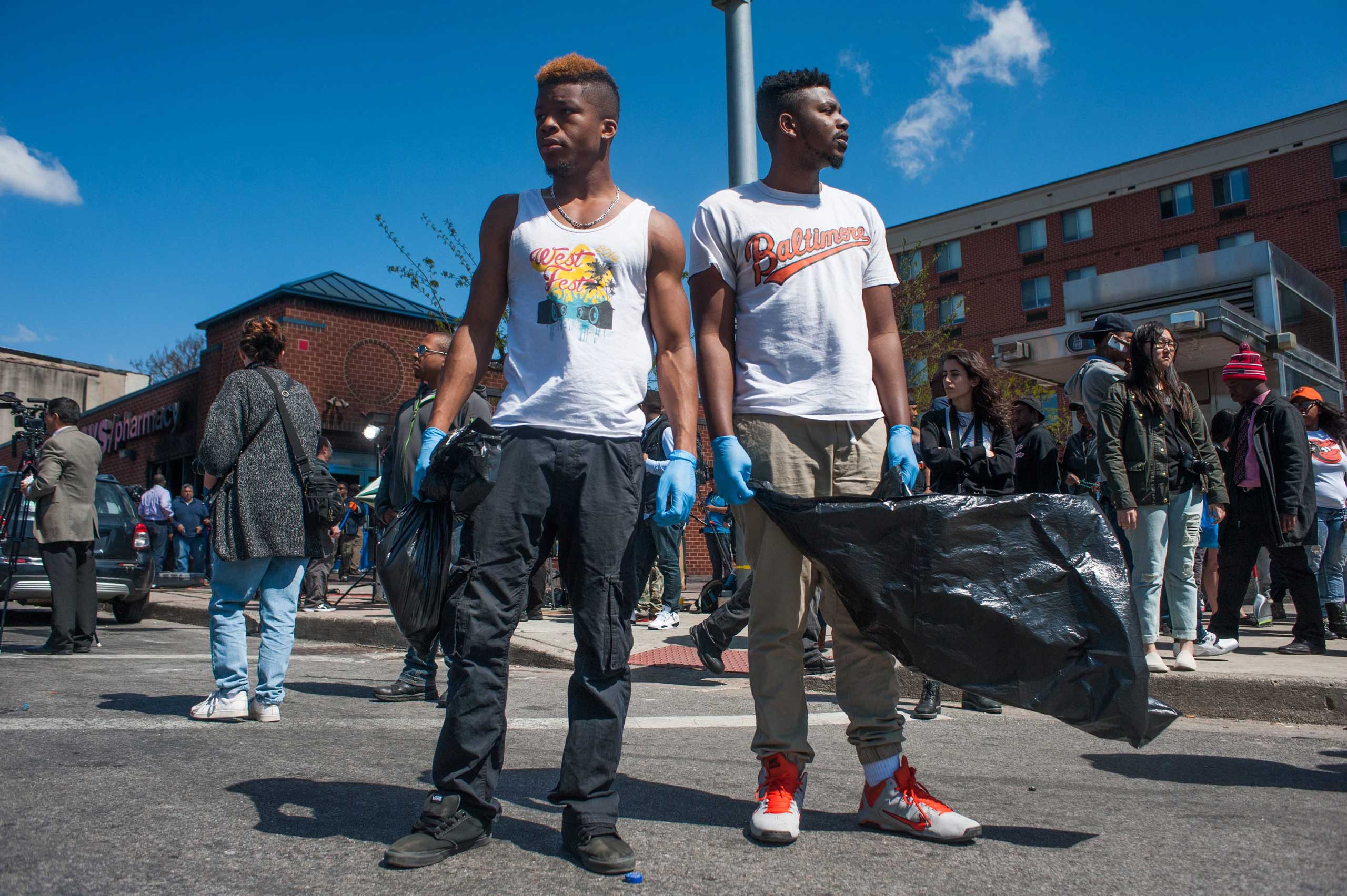 Cleanup volunteers stand in the intersection of North Avenue and Pennsylvania Avenue in the wake of riots in Baltimore on April 28, 2015.