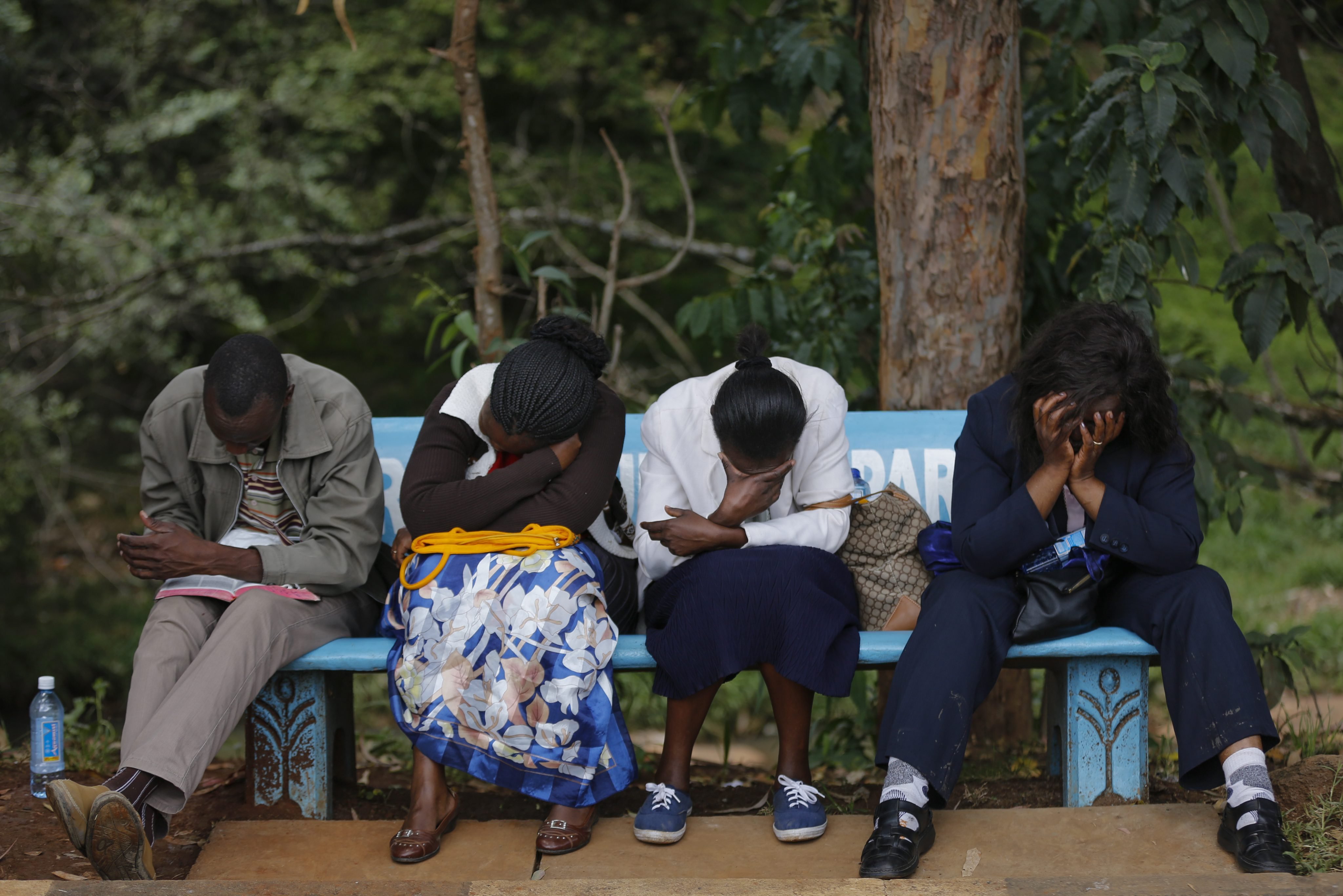 Family members sit on a bench as they wait to view the bodies of their loved ones who had been killed in an attack on Garissa University College, at a mortuary in Nairobi on April 8, 2015.