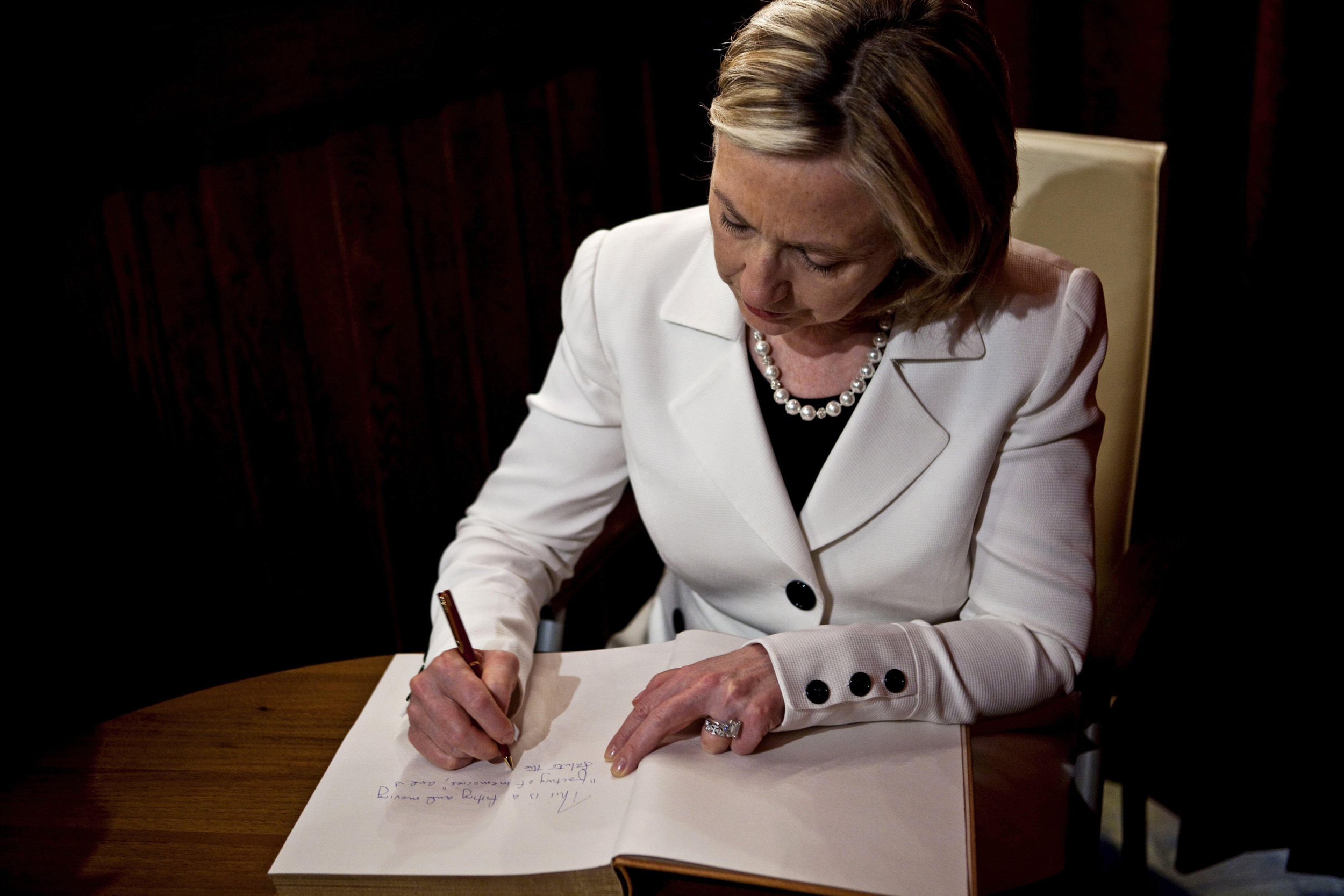 Secretary of State Hillary Rodham Clinton signs the guest book at the Schindler Factory Museum in Krakow, Poland on July 3, 2010. (Drew Angerer—AFP/Getty Images)