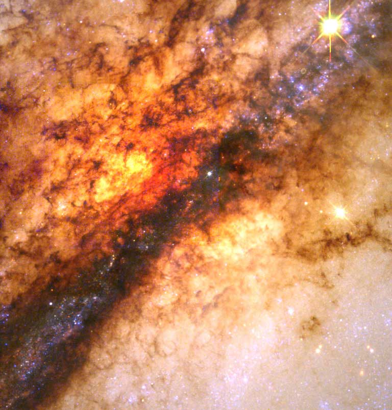 Nucleus of Galaxy Centaurus A:
                              Astronomers have obtained an unprecedented look at the nearest example of galactic cannibalism — a massive black hole hidden at the center of a nearby giant galaxy that is feeding on a smaller galaxy in a spectacular collision. Such fireworks were common in the early universe, as galaxies formed and evolved, but are rare today.
                              
                              The Hubble telescope offers a stunning unprecedented close-up view of a turbulent firestorm of star birth along a nearly edge-on dust disk girdling Centaurus A, the nearest active galaxy to Earth. The picture at upper left shows the entire galaxy. The blue outline represents Hubble's field of view. The larger, central picture is Hubble's close-up view of the galaxy. Brilliant clusters of young blue stars lie along the edge of the dark dust lane. Outside the rift the sky is filled with the soft hazy glow of the galaxy's much older resident population of red giant and red dwarf stars.
                              Imaged released on May 14, 1998.