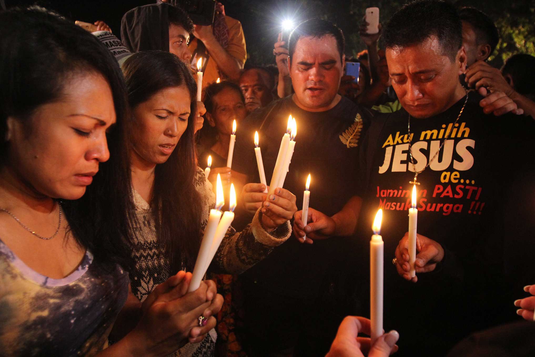 People hold candles to pray for death-row prisoners at Wijayapura port in Cilacap, Indonesia on April 29, 2015.