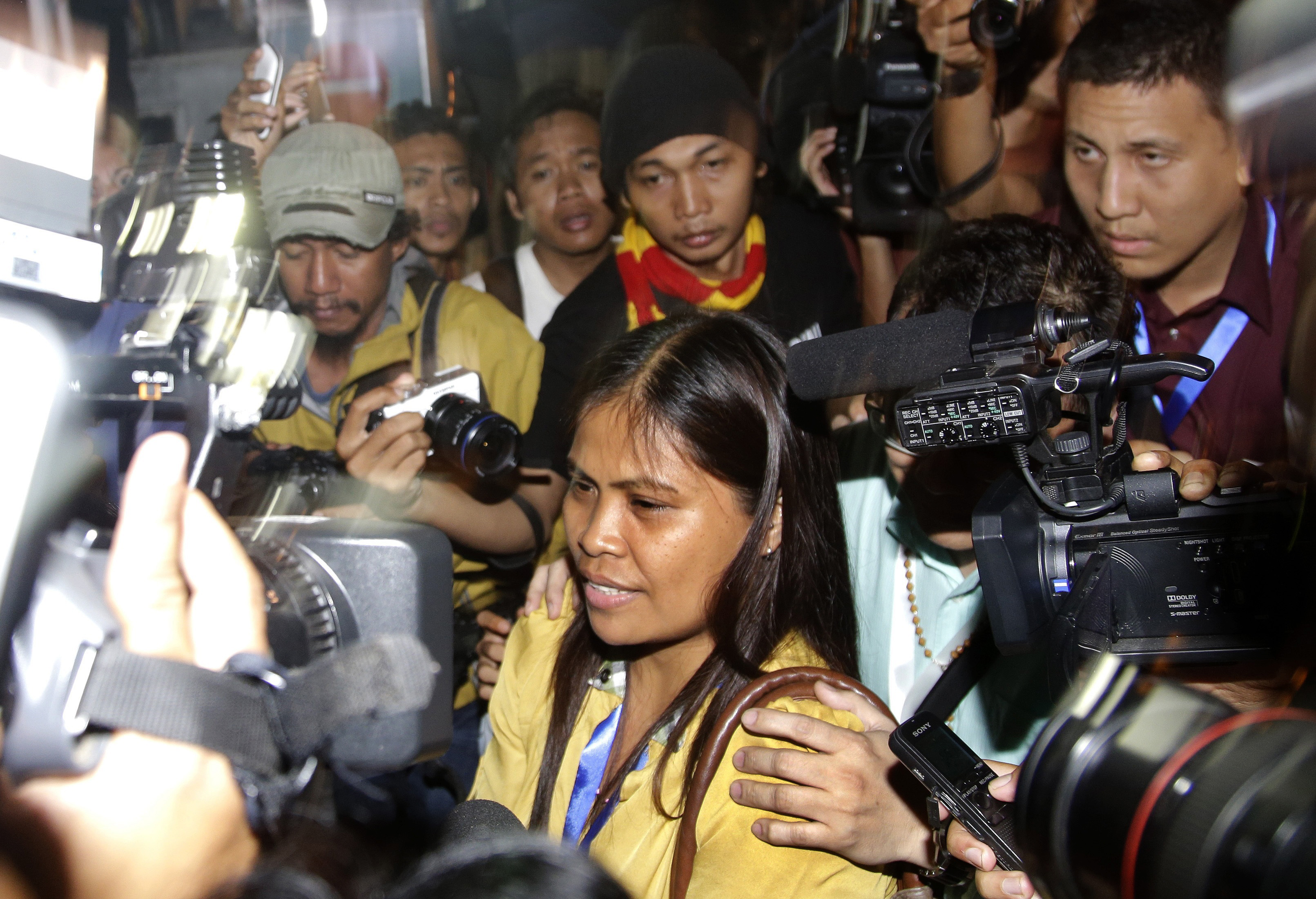 Marites Veloso, front center, sister of Filipina migrant worker on death row for drug offenses Mary Jane Veloso, is surrounded by media at Wijayapura port in Cilacap, Indonesia, after visiting her sister on April 29, 2015 (Tatan Syuflana—AP)
