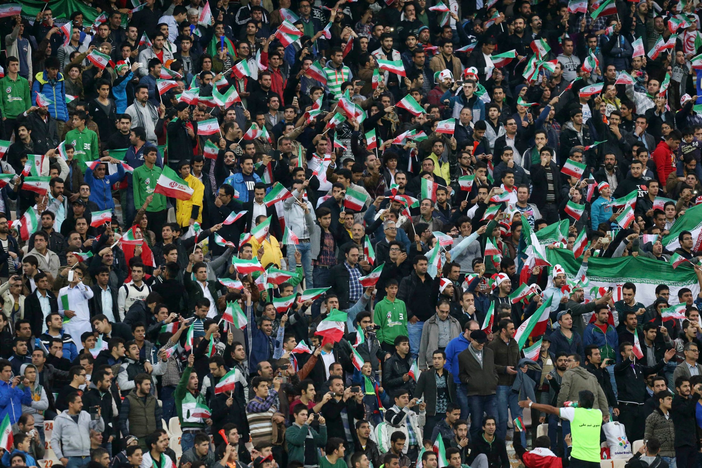 Iranian soccer supporters wave their country's flag following a friendly match at the Azadi, (freedom) stadium in Tehran, Iran on Nov. 18, 2014.