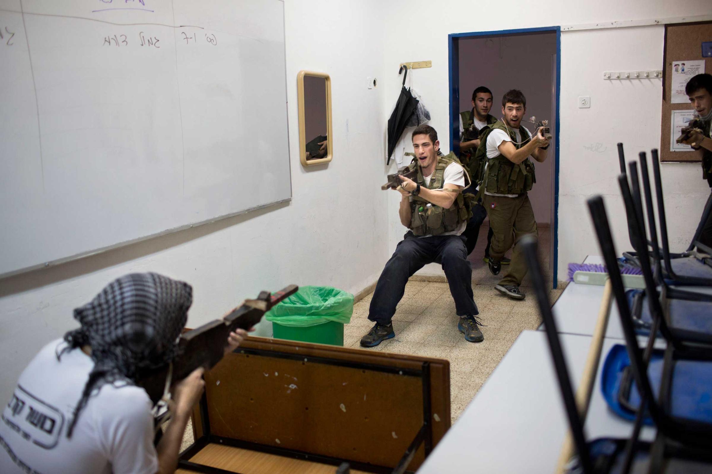 Israeli high-school seniors preparing to join the Israeli military participate in an urban fighting drill as part of privately run military combat fitness training, in Kibbutz Mizra, northern Israel, March 24, 2015.
