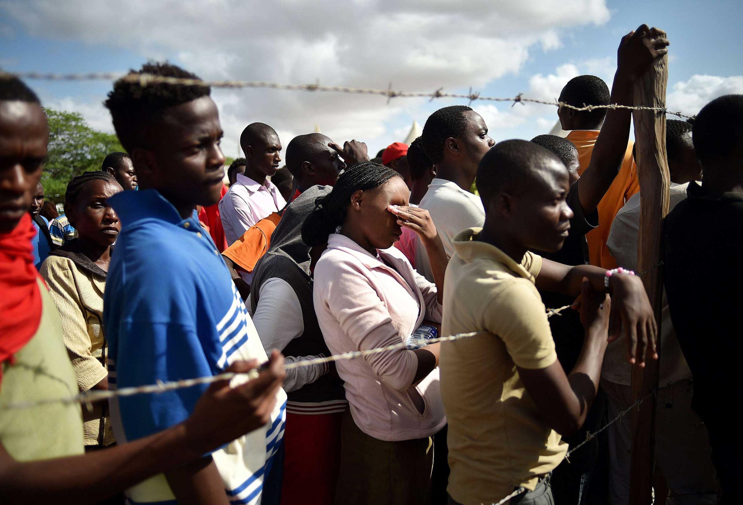 Students evacuated from Garissa University listen to an address by Interior Minister for Security Joseph Ole Nkaissery before they are transported to their home regions from a holding area on April 3, 2015.