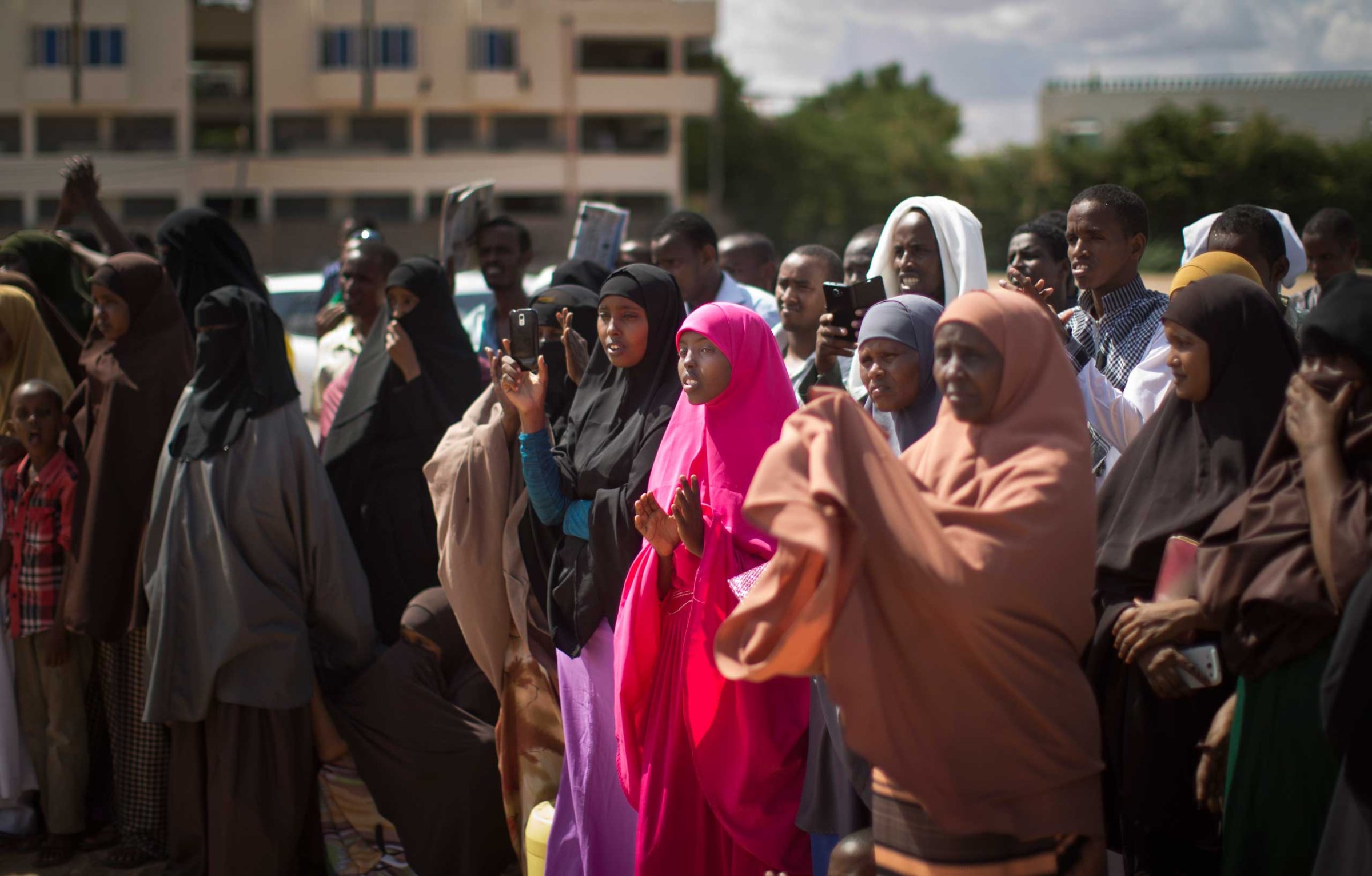 Kenyan Muslim women and men applaud as a women's representative denounces the latest attack by al-Shabab gunmen, at a public meeting in Garissa, Kenya, on Apr. 3, 2015.