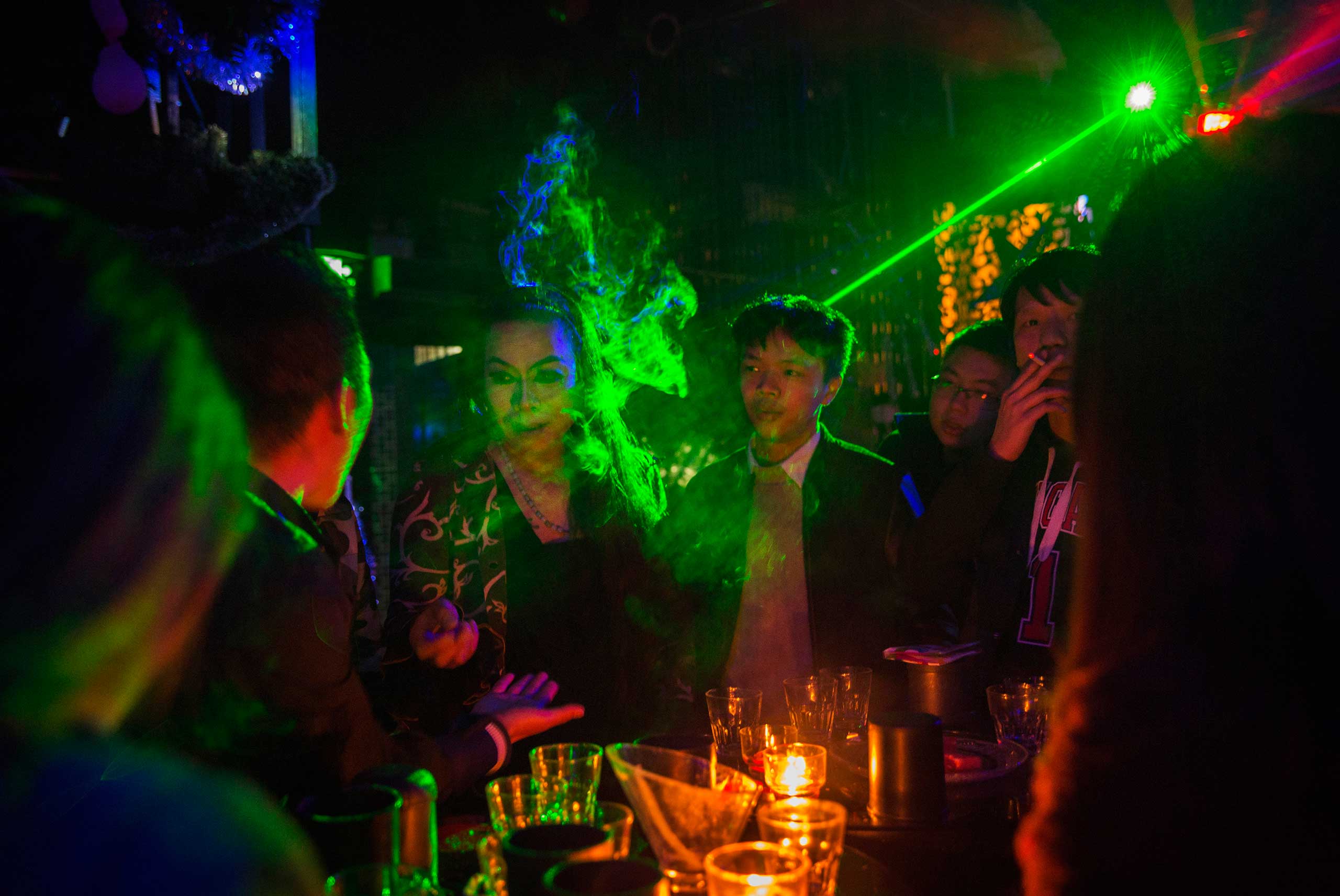 Chinese drag queen who goes by the name Shancun, third from left, has a drink with customers after performing at the Chunai 98 club in Nanning, Guangxi Province, southern China, Jan. 10, 2015.