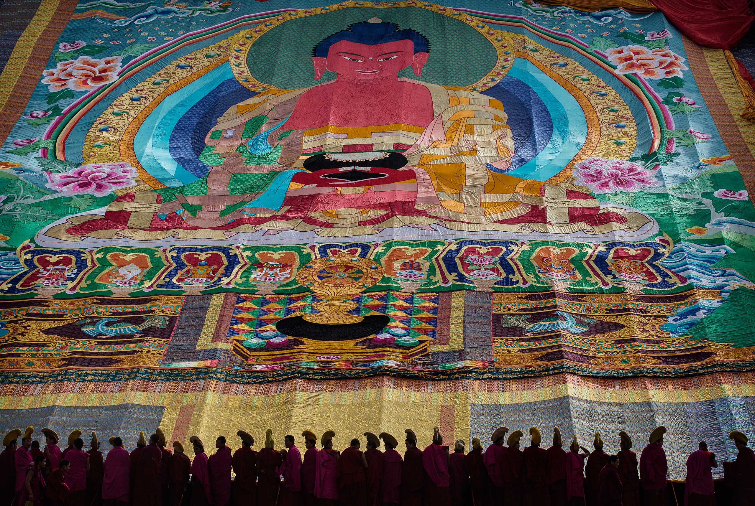 From the series: Tibetan Buddhists Celebrate Religion And Culture at Great PrayerTibetan Buddhist monks stand below a large painting of the Buddhaduring Monlam or the Great Prayer rituals at the Labrang Monastery, Xiahe County, Amdo, Tibetan Autonomous Prefecture, Gansu Province, China, March 3, 2015.