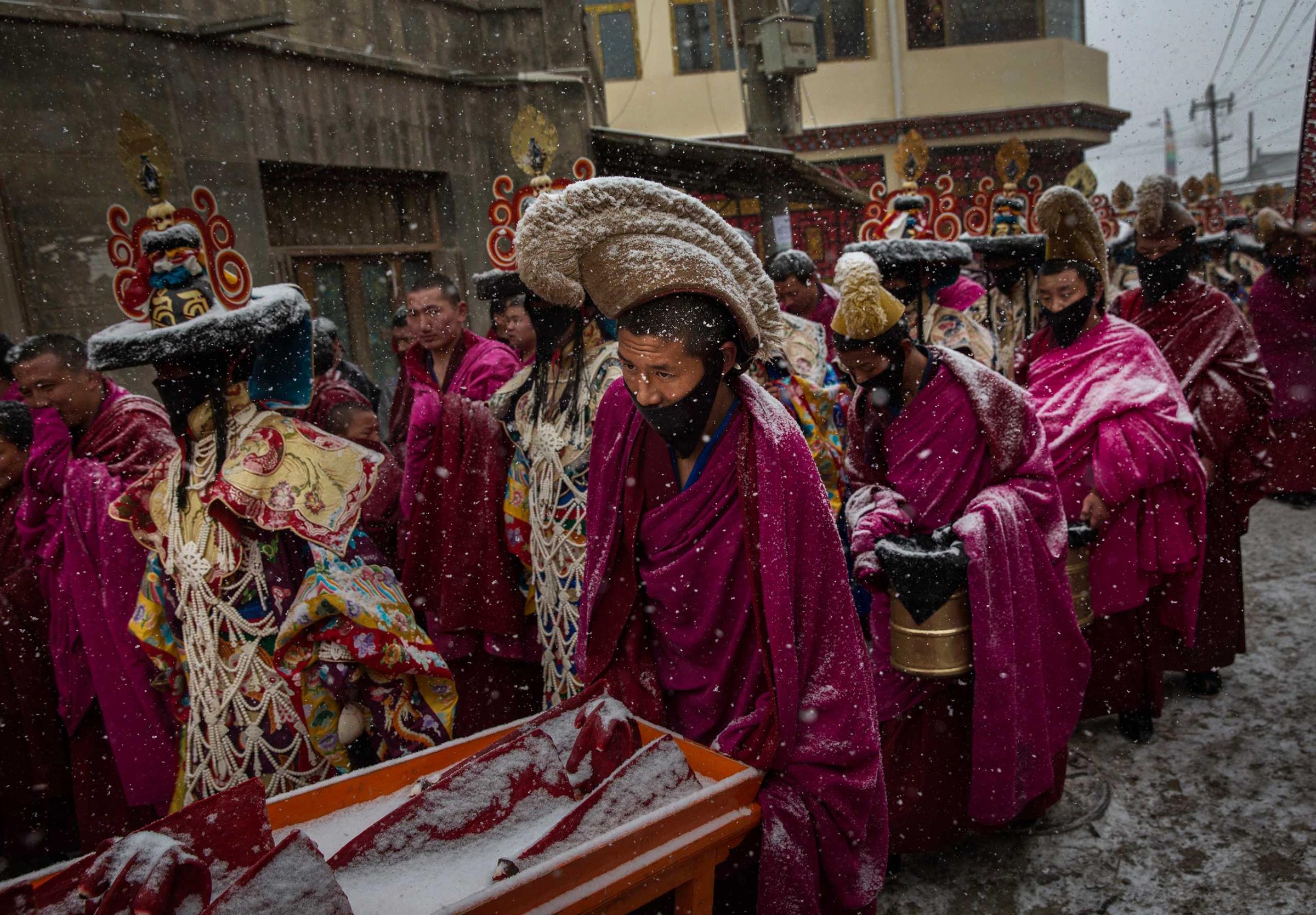 Tibetan Buddhist monks walk in a procession in the snow during Monlam or the Great Prayer rituals at the Labrang Monastery, Xiahe County, Amdo, Tibetan Autonomous Prefecture, Gansu Province, China, March 4, 2015.