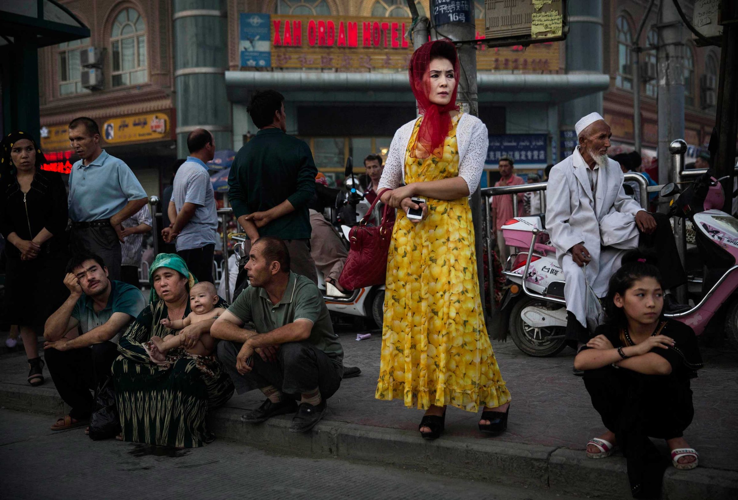 Uighurs wait at a bus stop in old Kashgar, Xinjiang Province, China, July 27, 2014.