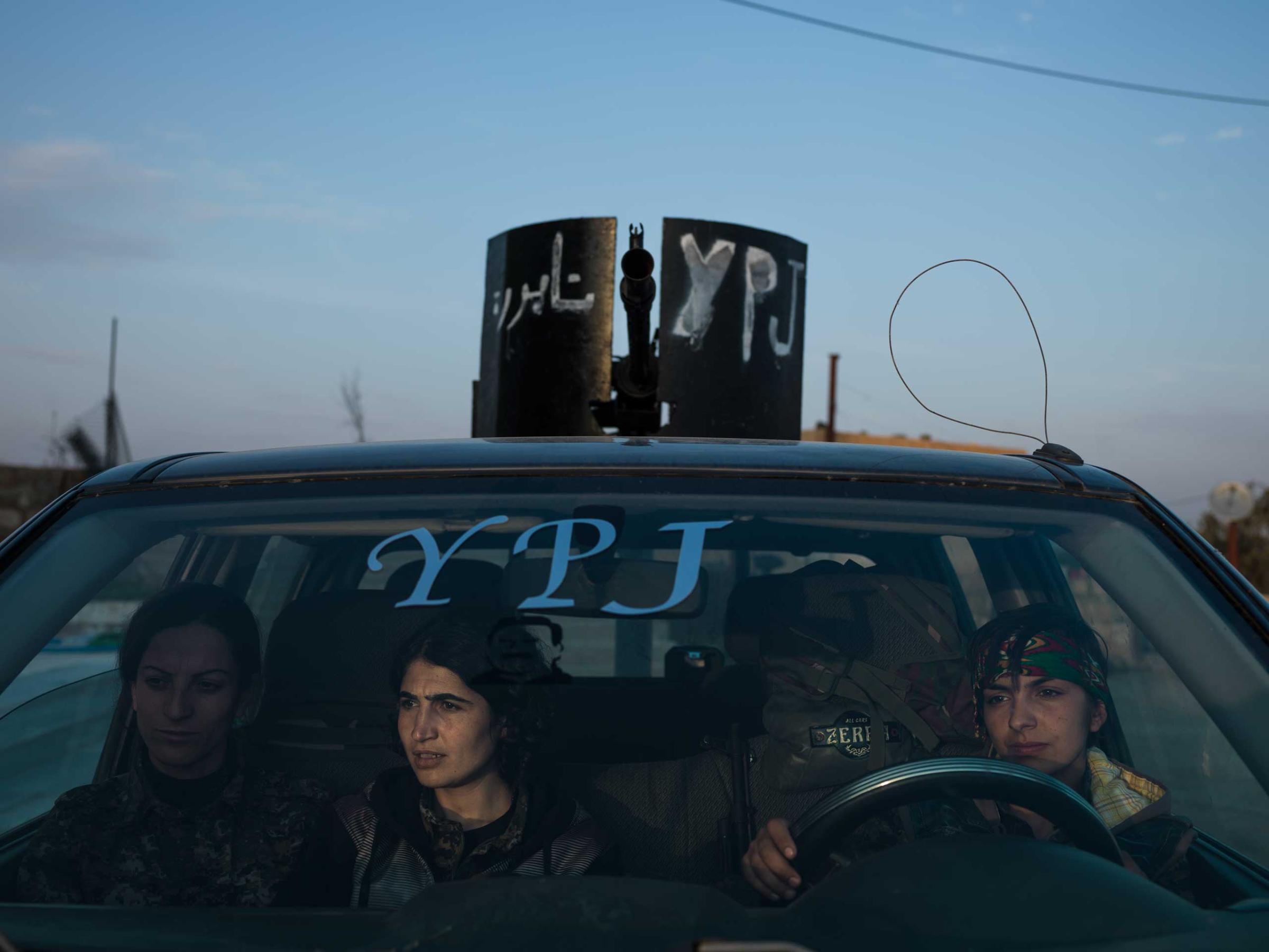 Three YPJ fighters sit in an armed vehicle at their basein eastern Syria, days after returning from the front. Newsha Tavakolian for TIME