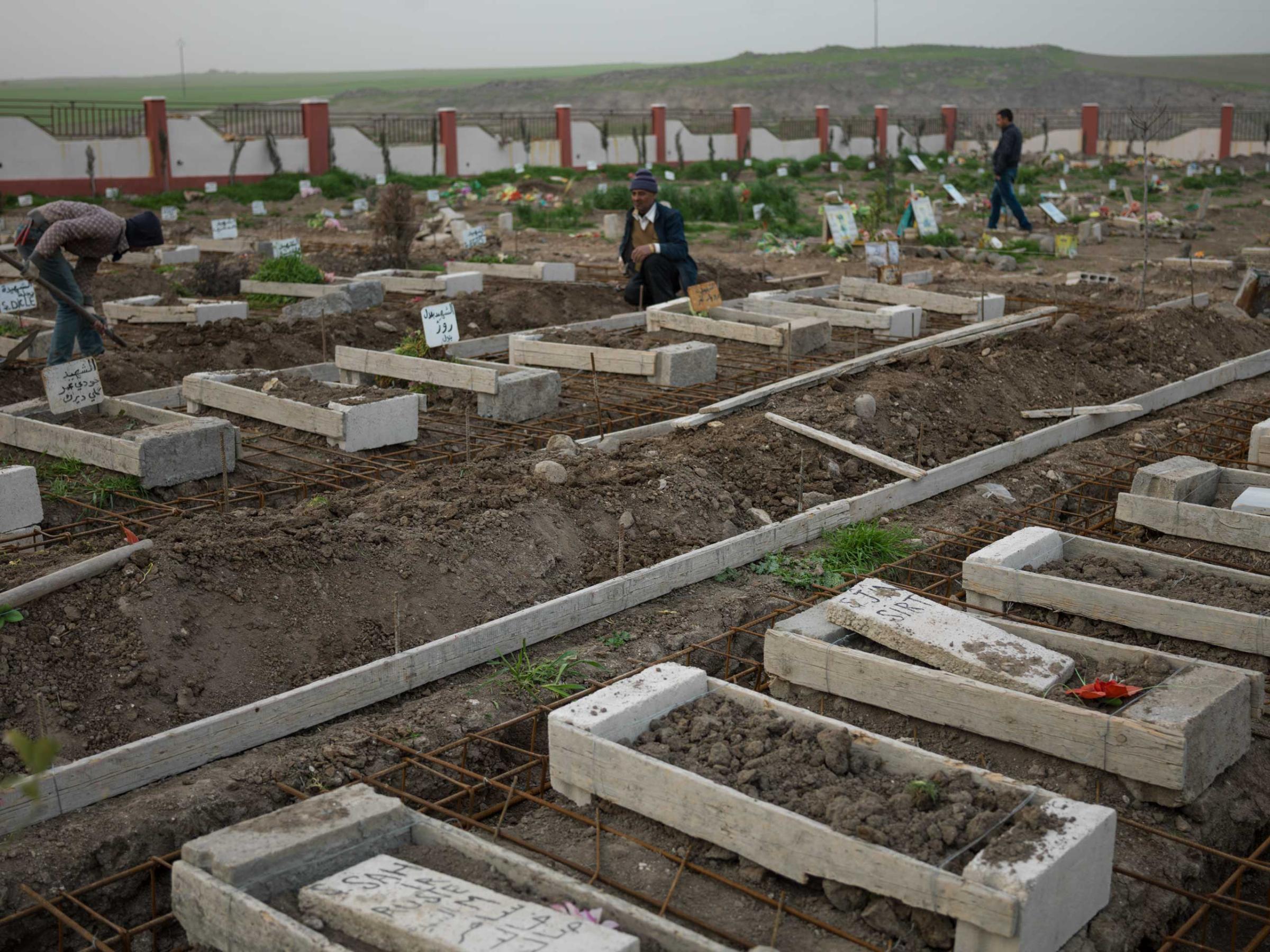 in Syria, graves of YPJ members who were killed fighting ISIS. In the foreground, female fighters are buried together.Newsha Tavakolian for TIME