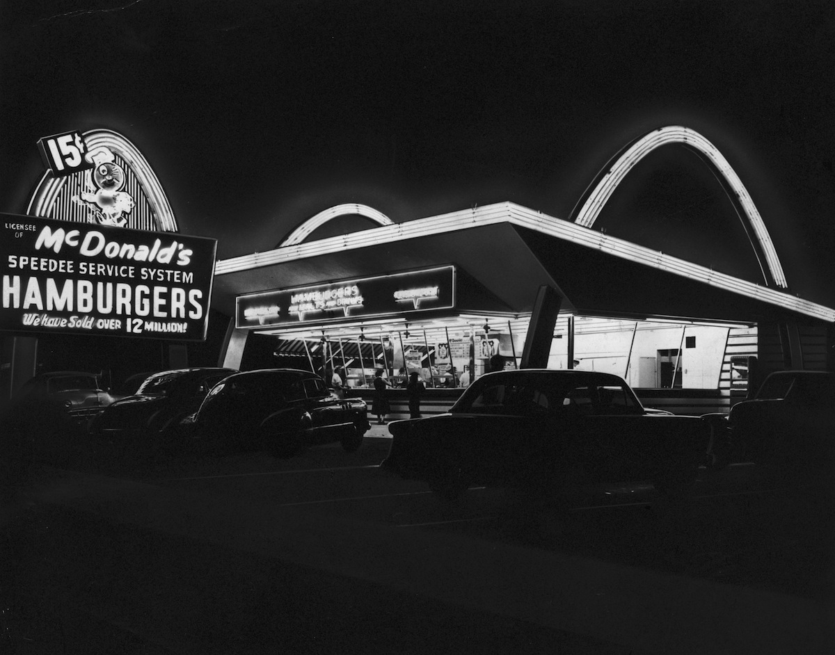 The first McDonald's fast food franchise with its neon arches illuminated at night, Des Plaines, Ill., circa 1955 (Hulton Archive / Getty Images)