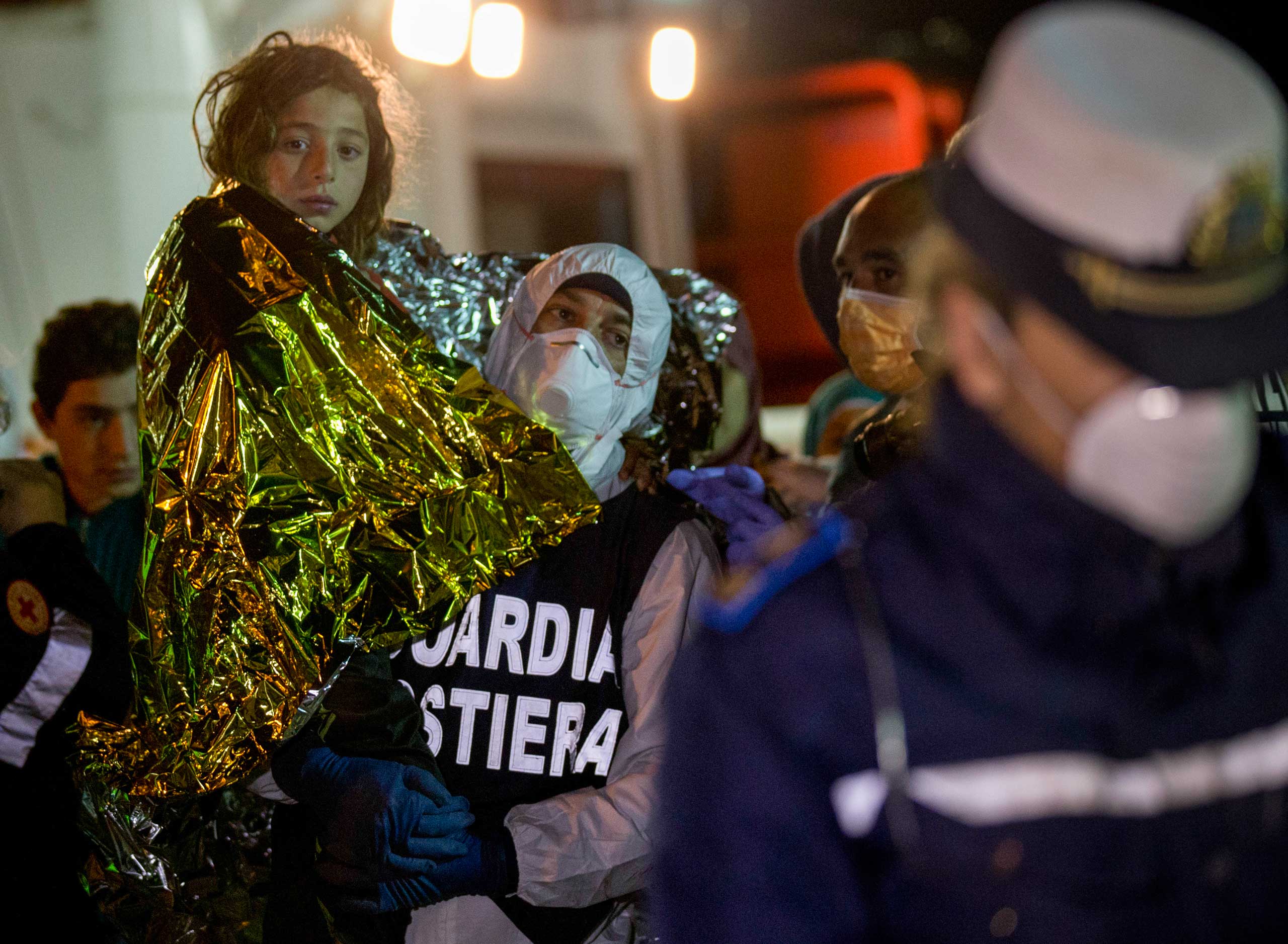 A migrant is helped disembark in the Sicilian harbor of Pozzallo, Italy, early, April 20, 2015. (Alessandra Tarantino—AP)