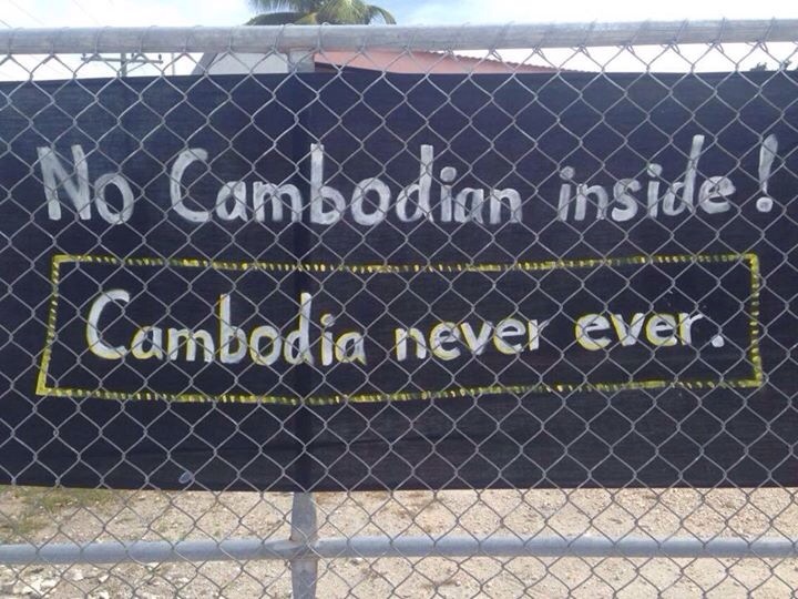 A banner fixed to a fence on Anibare Lodge, the main camp for refugee families on Nauru, reads "Cambodia, never, ever," March 7, 2015.