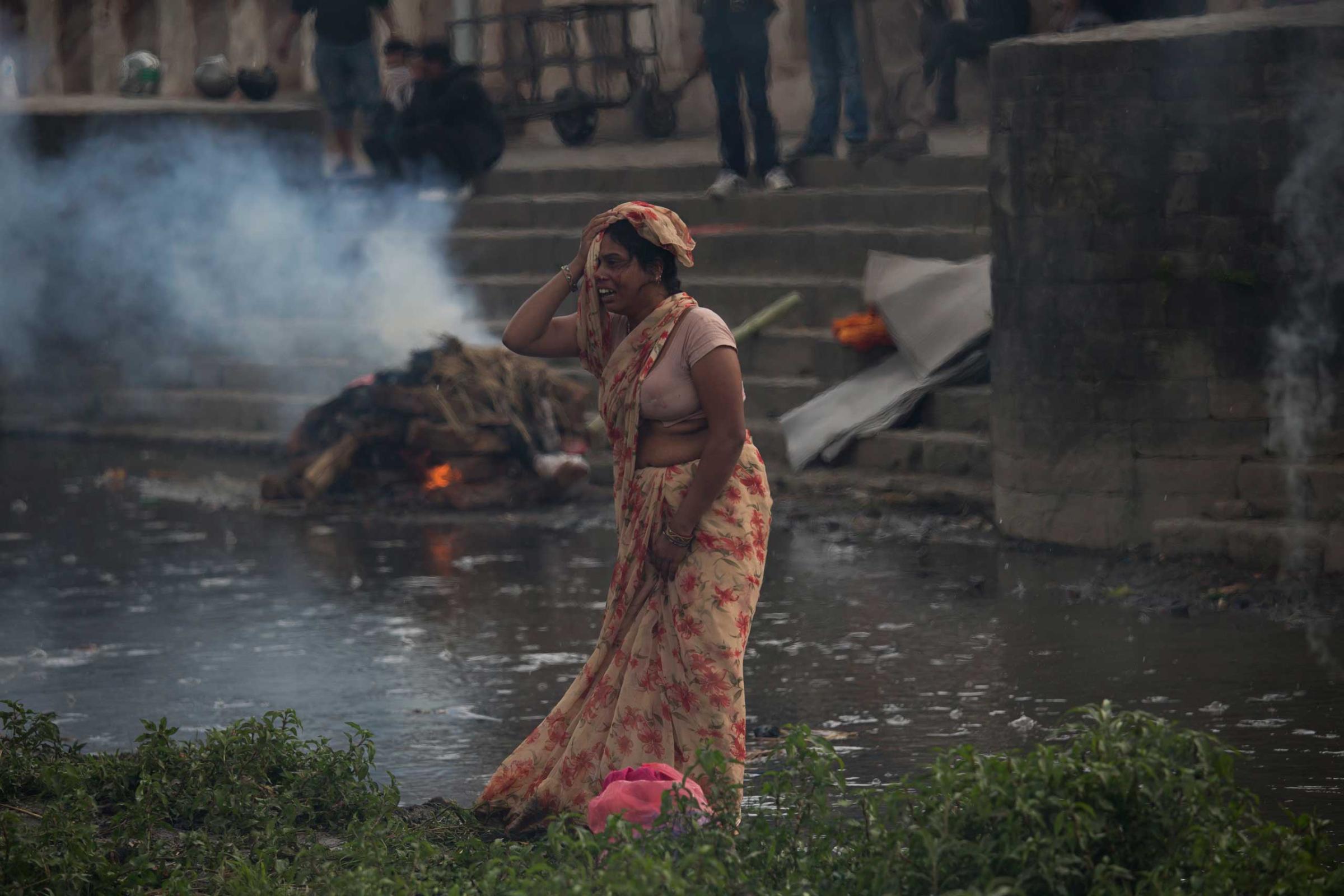 A woman weeps during the cremation of a victim of Saturdayís earthquake, at the Pashupatinath temple, on the banks of Bagmati river, in Kathmandu on April 26, 2015.