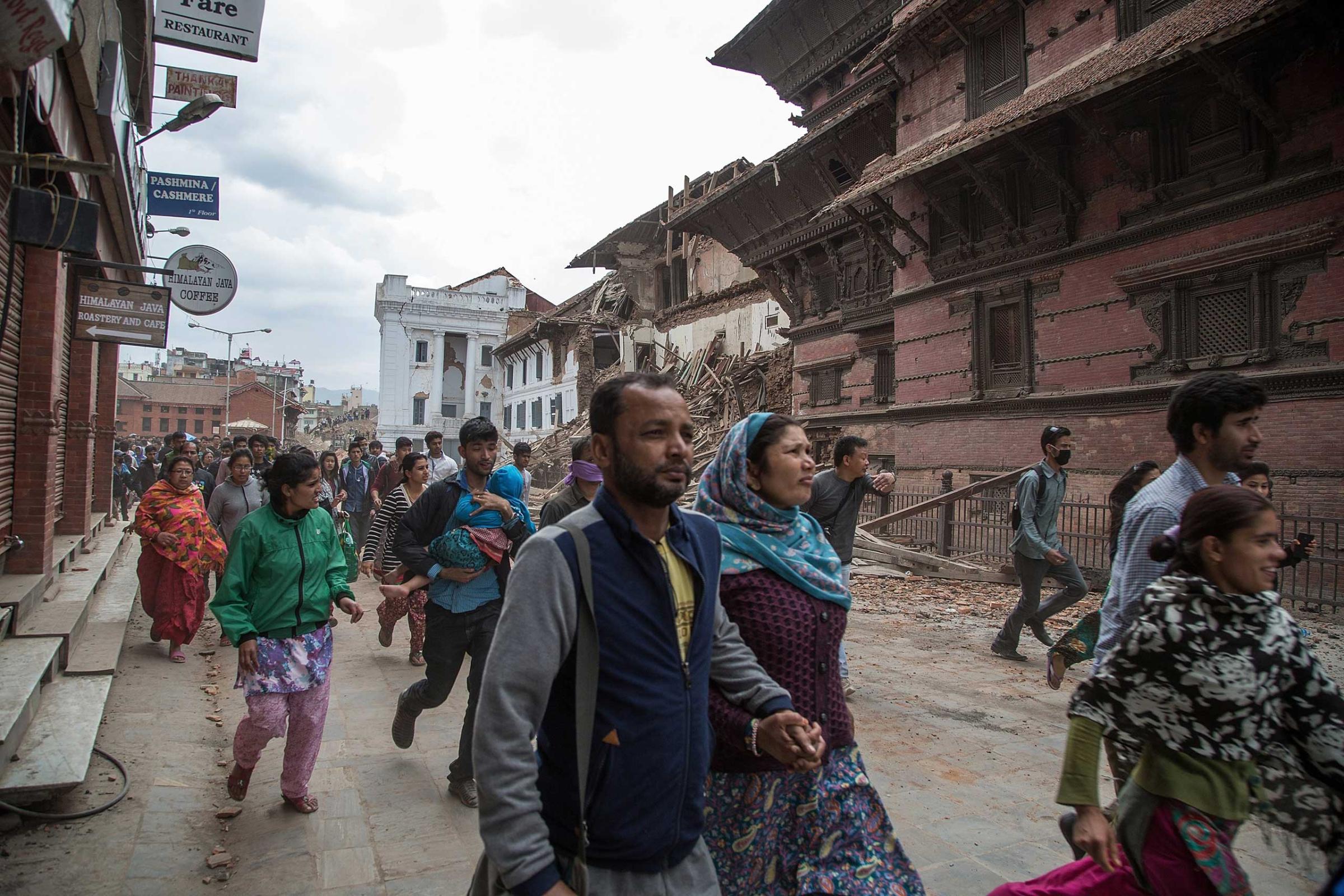Residents run to shelters after an aftershock hit Kathmandu on April 25, 2015.