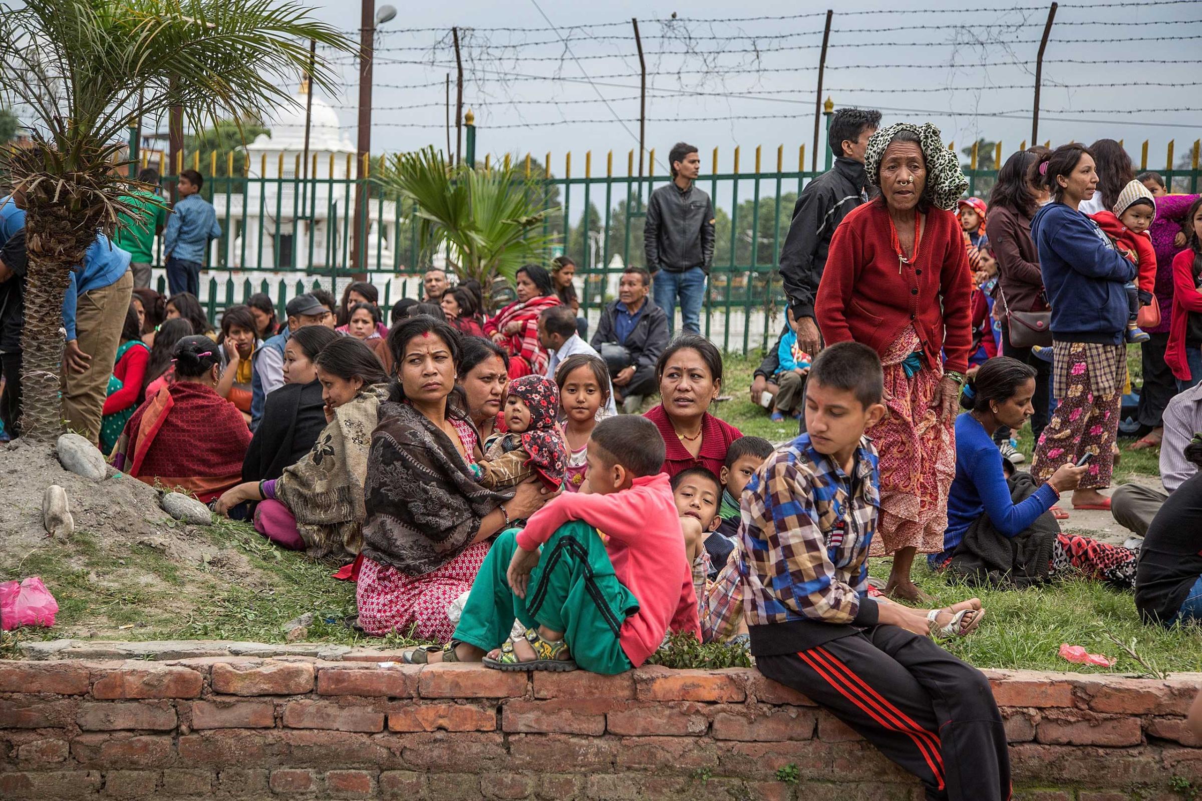 Residents sit in open spaces as aftershocks hit the city following an earthquake in Kathmandu on April 25, 2015.