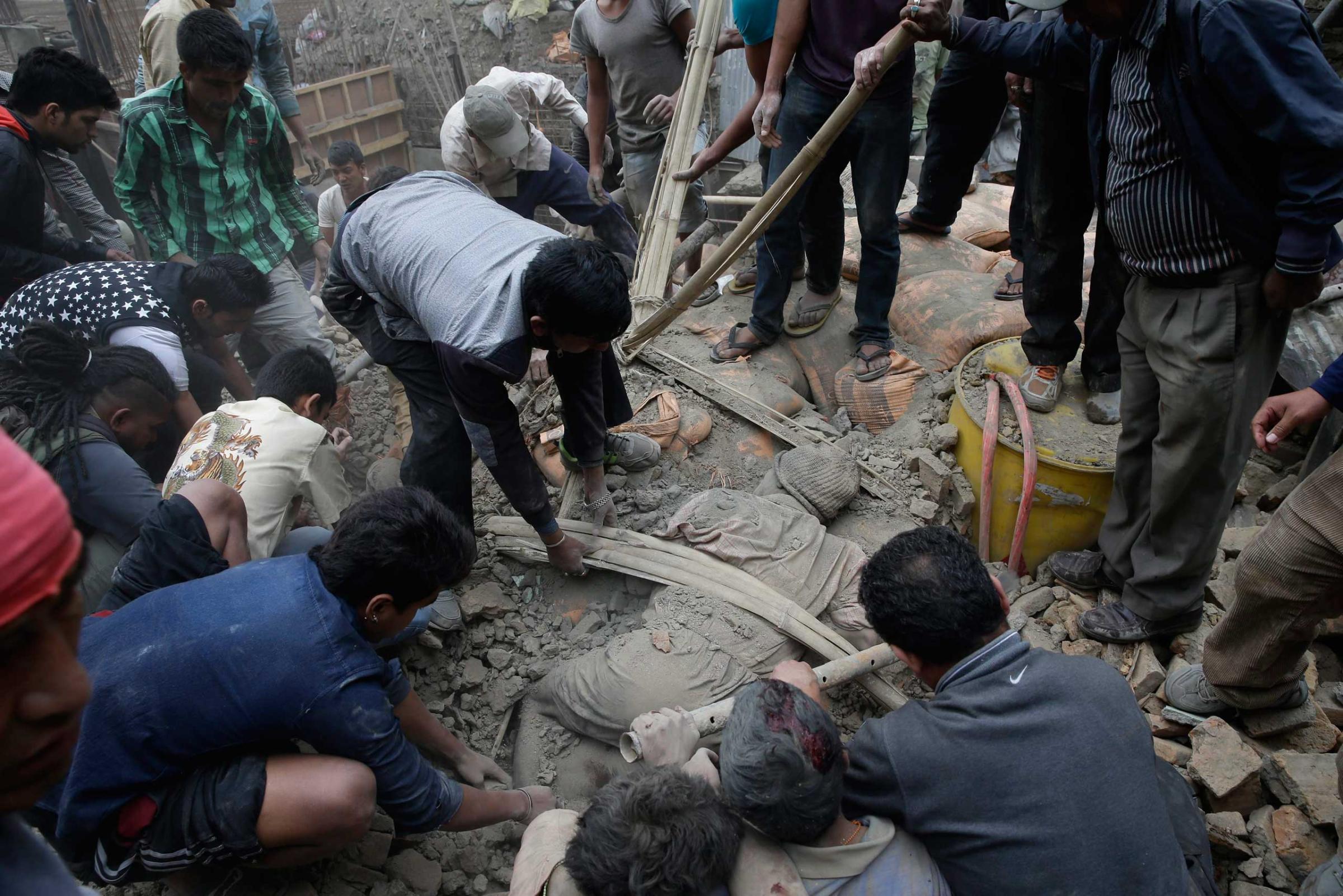 People try to free a man from the rubble of a destroyed building after an earthquake in Kathmandu, Nepal on April 25, 2015.