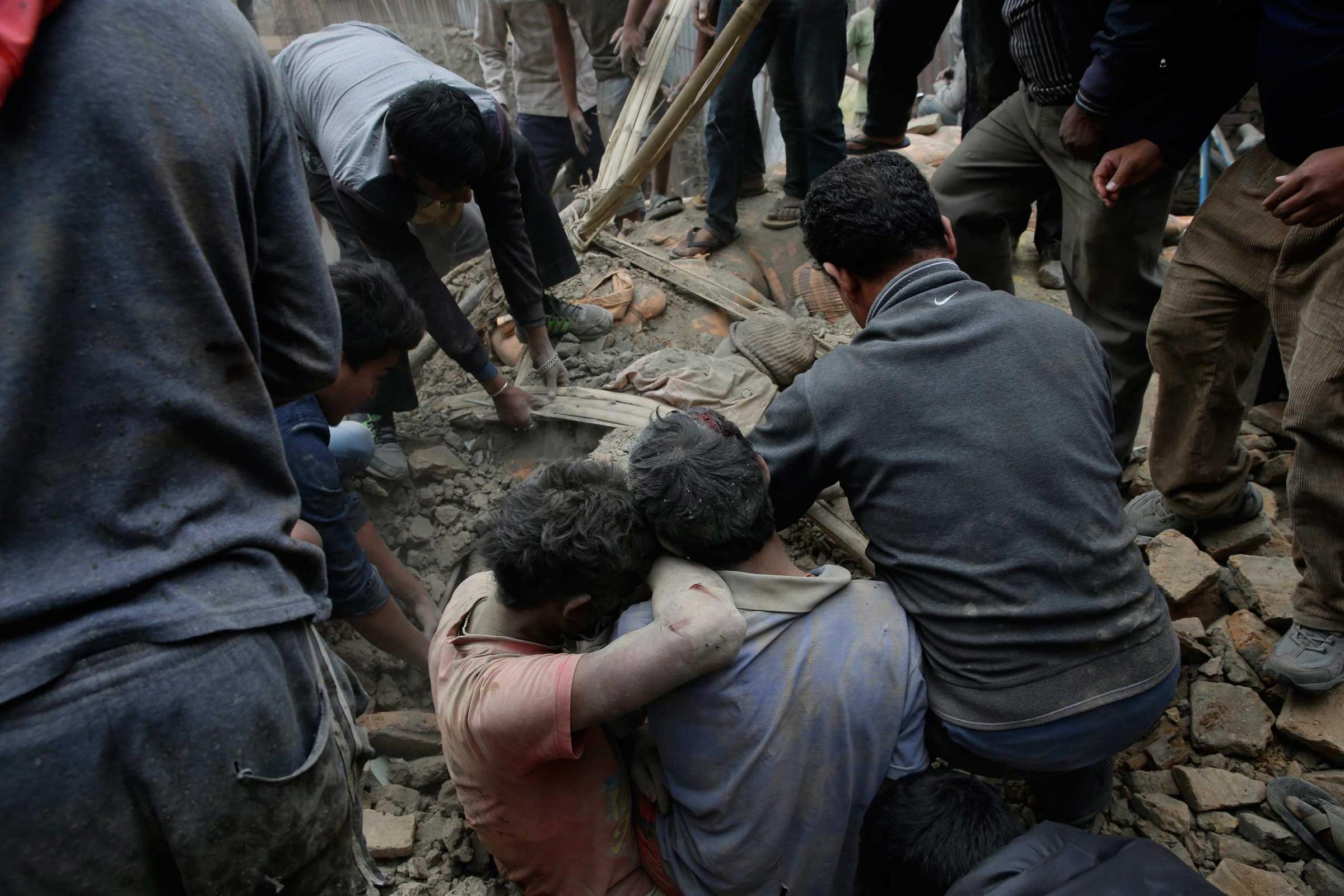 People try to dig out bodies from under the rubble of a destroyed building after an earthquake in Kathmandu, Nepal on April 25, 2015.
