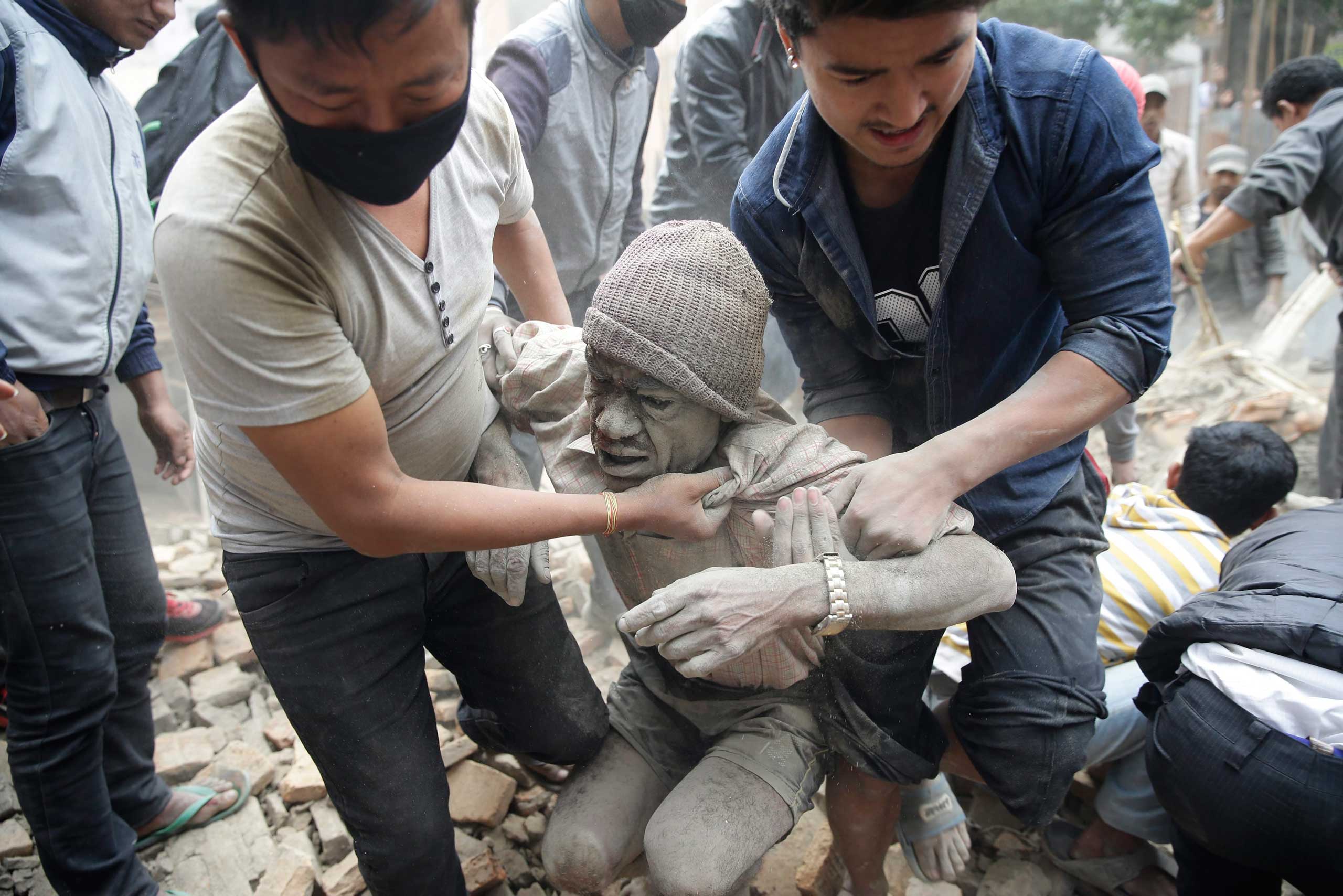 People free a man from the rubble of a destroyed building after an earthquake in Kathmandu, Nepal on April 25, 2015.