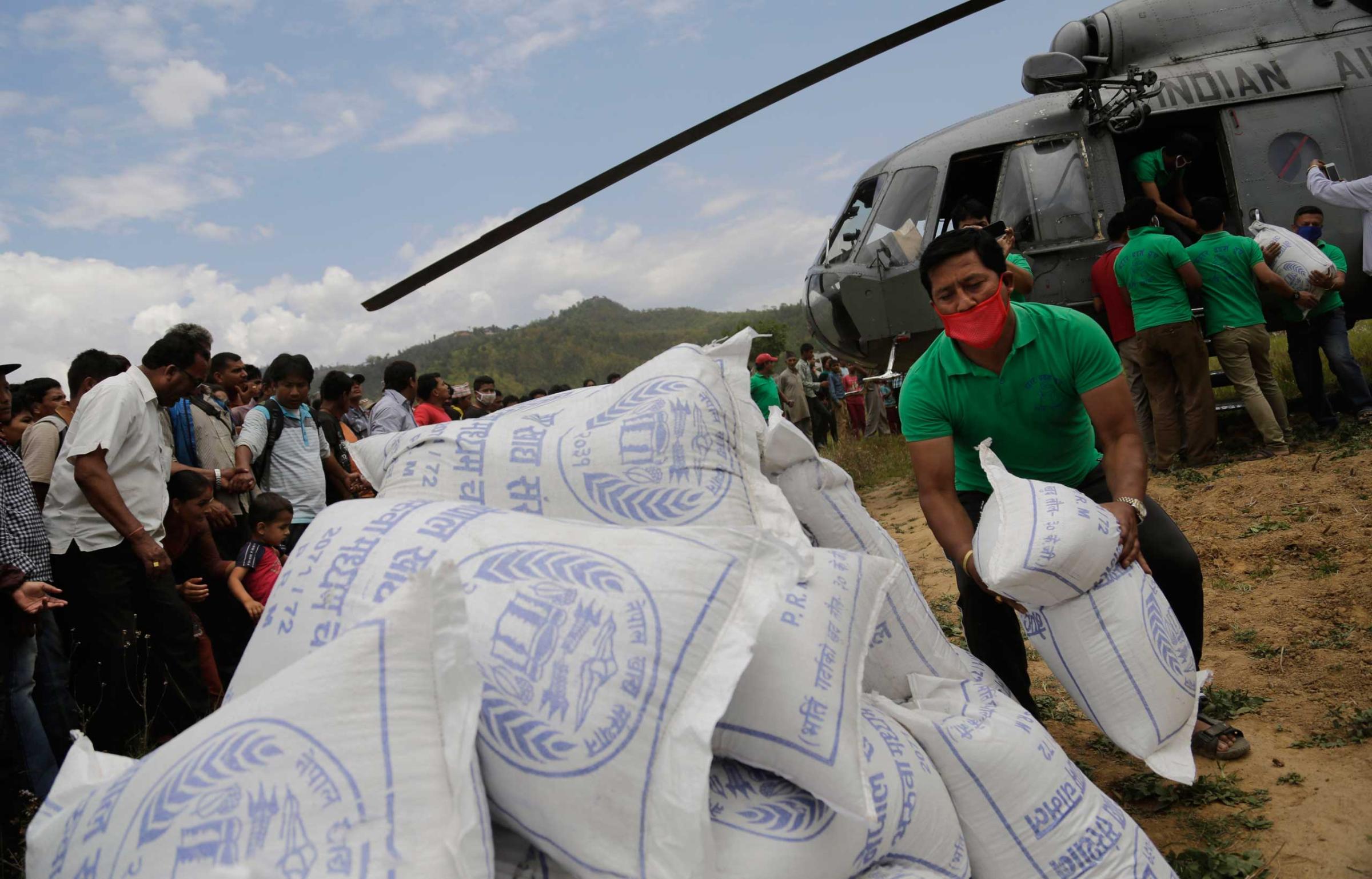 Nepalese volunteers unload relief material, brought by an Indian Air Force helicopter for victims of Saturday's earthquake at Trishuli Bazar in Nepal on April 27, 2015.