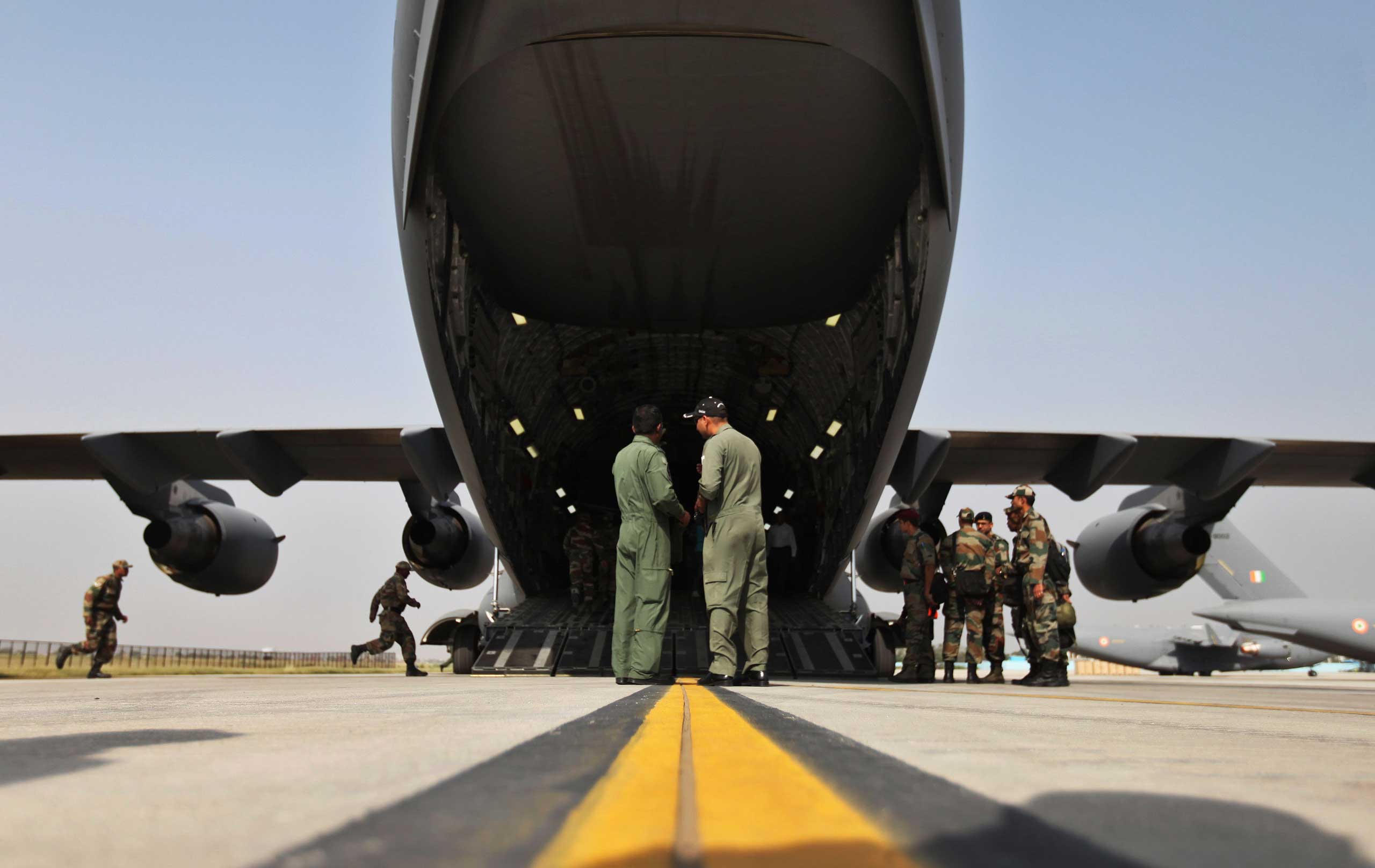 Indian soldiers, left, on a rescue mission to Nepal rush to board an Indian Air Force aircraft near New Delhi on April 26, 2015.