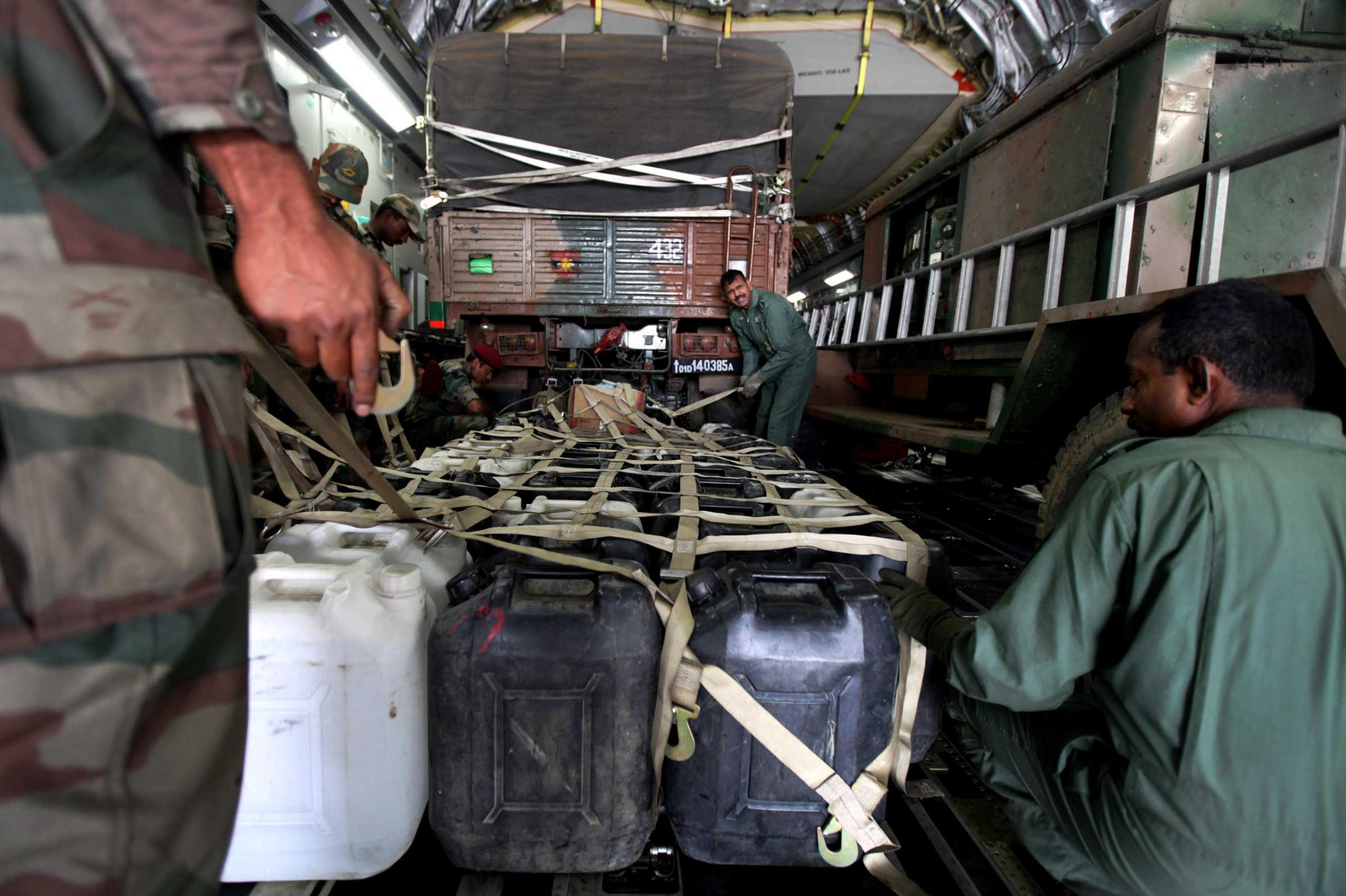 Plastic containers with drinking water are loaded into an Indian Air Force aircraft headed to Nepal, at a base near New Delhi on April 26, 2015.