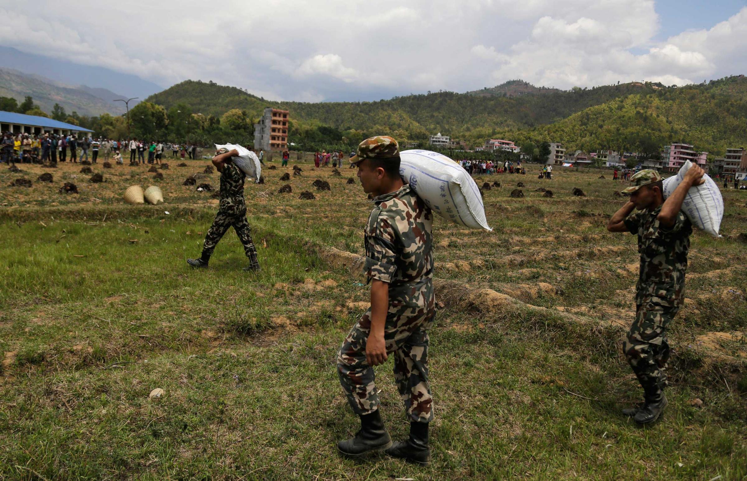 Nepalese soldiers unload relief material brought in an Indian air force helicopter for victims of Saturdayís earthquake at Trishuli Bazar in Nepal on April 27, 2015.