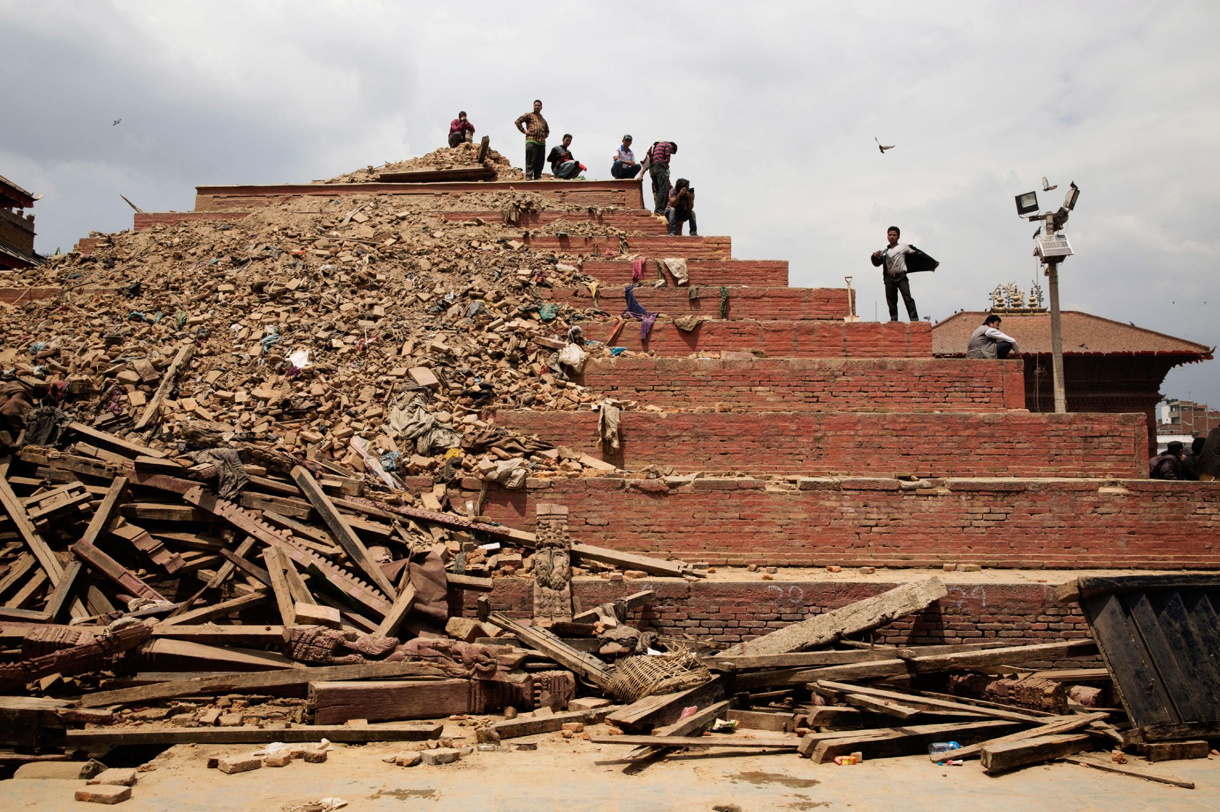 People atop damaged buildings in Durbar Square, Kathmandu, Nepal on April. 26, 2015. The historic Durbar Square, a UNESCO world heritage site, was severely damaged in an earthquake on April 25th. Photo by Adam Ferguson for Time
