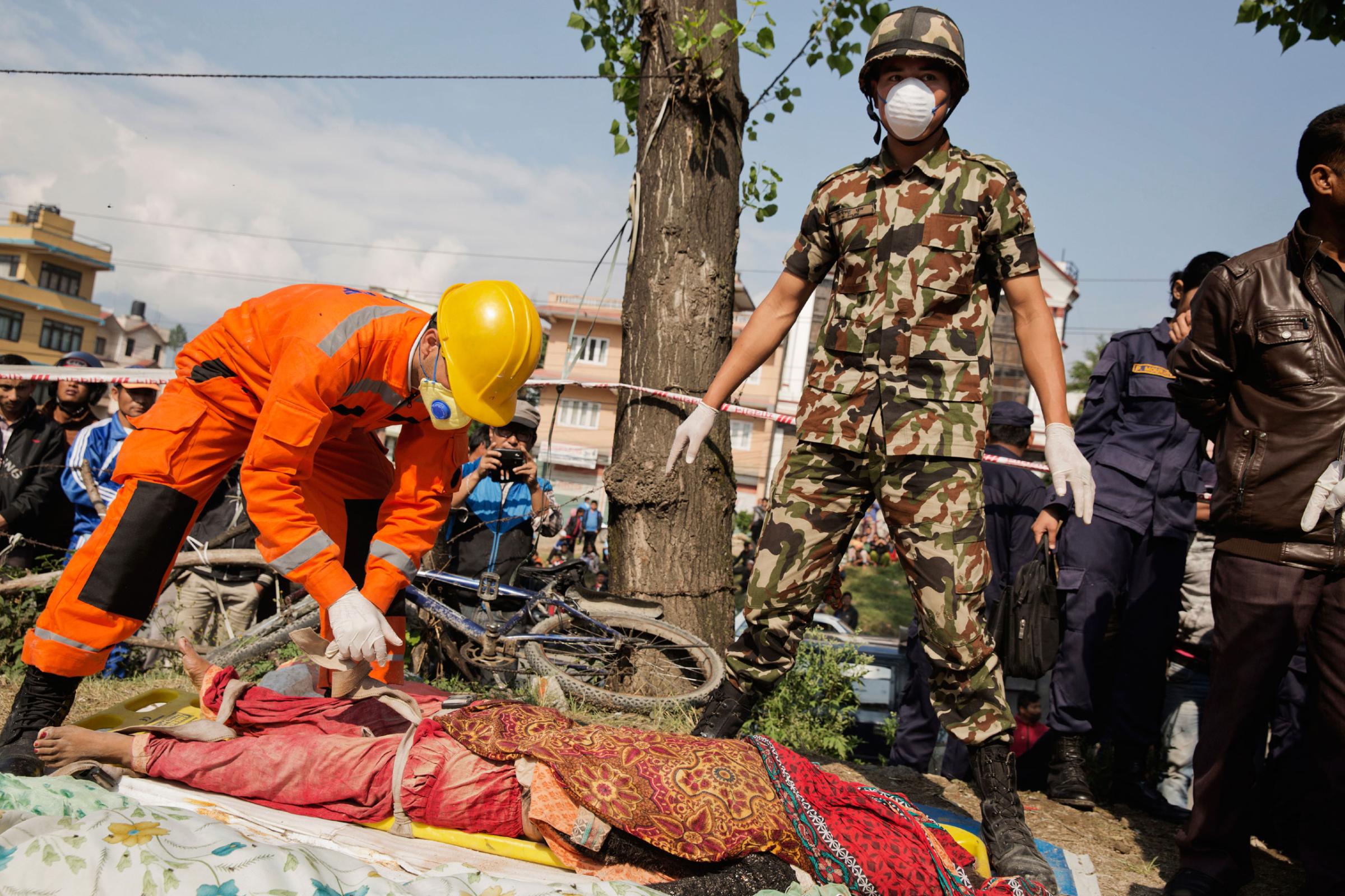 Indian and Nepali forces attempt to identify a body after it was recovered from a collapsed restaurant in Kathmandu, Nepal on April. 27, 2015. Nepal had a severe earthquake on April 25th. Photo by Adam Ferguson for Time
