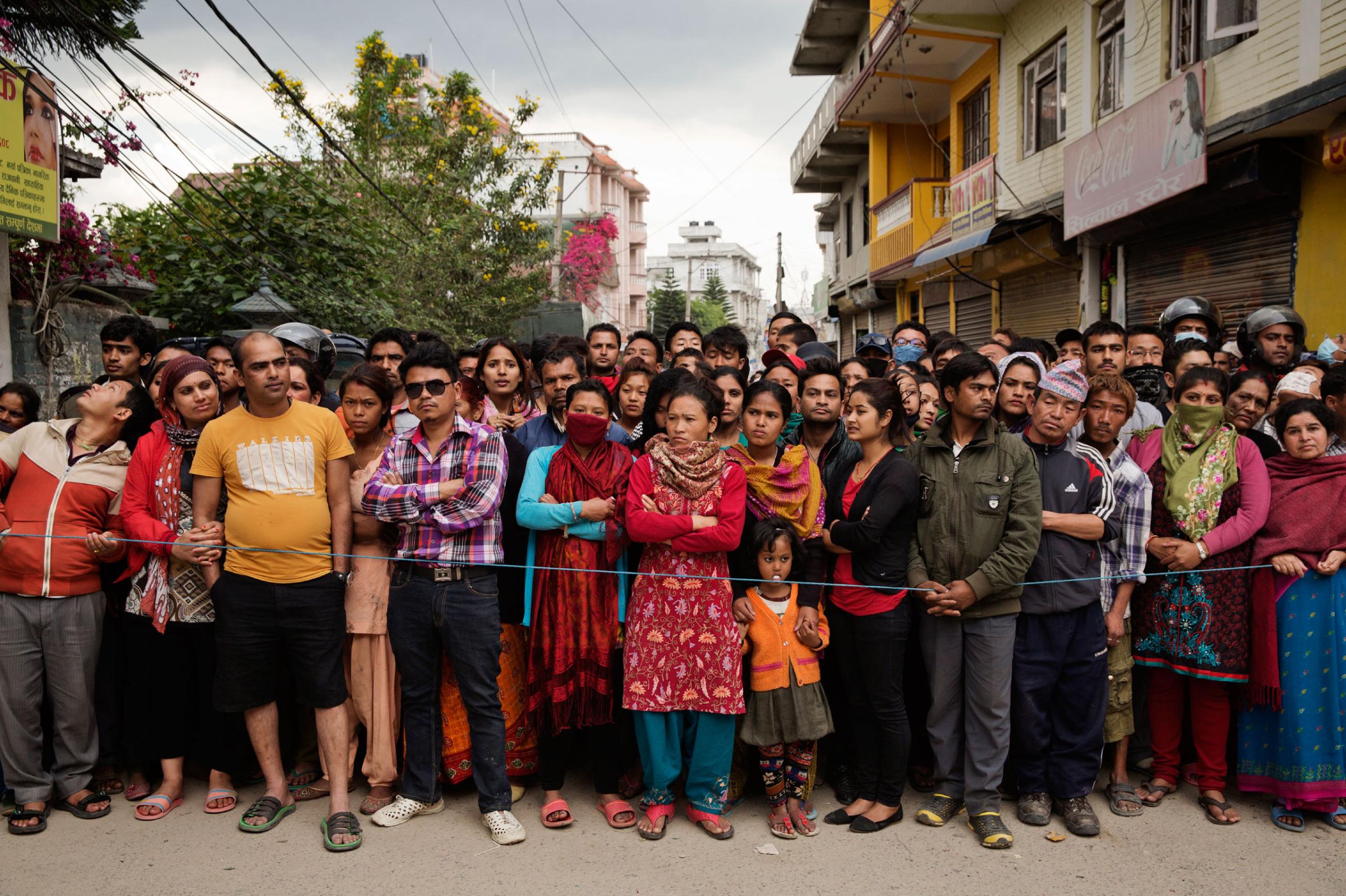 A crowd watches Indian forces excavating collapsed apartments looking for bodies and survivors of Saturdays Earthquake, in Kathmandu, Nepal on April. 27, 2015. Nepal had a severe earthquake on April 25th. Photo by Adam Ferguson for Time