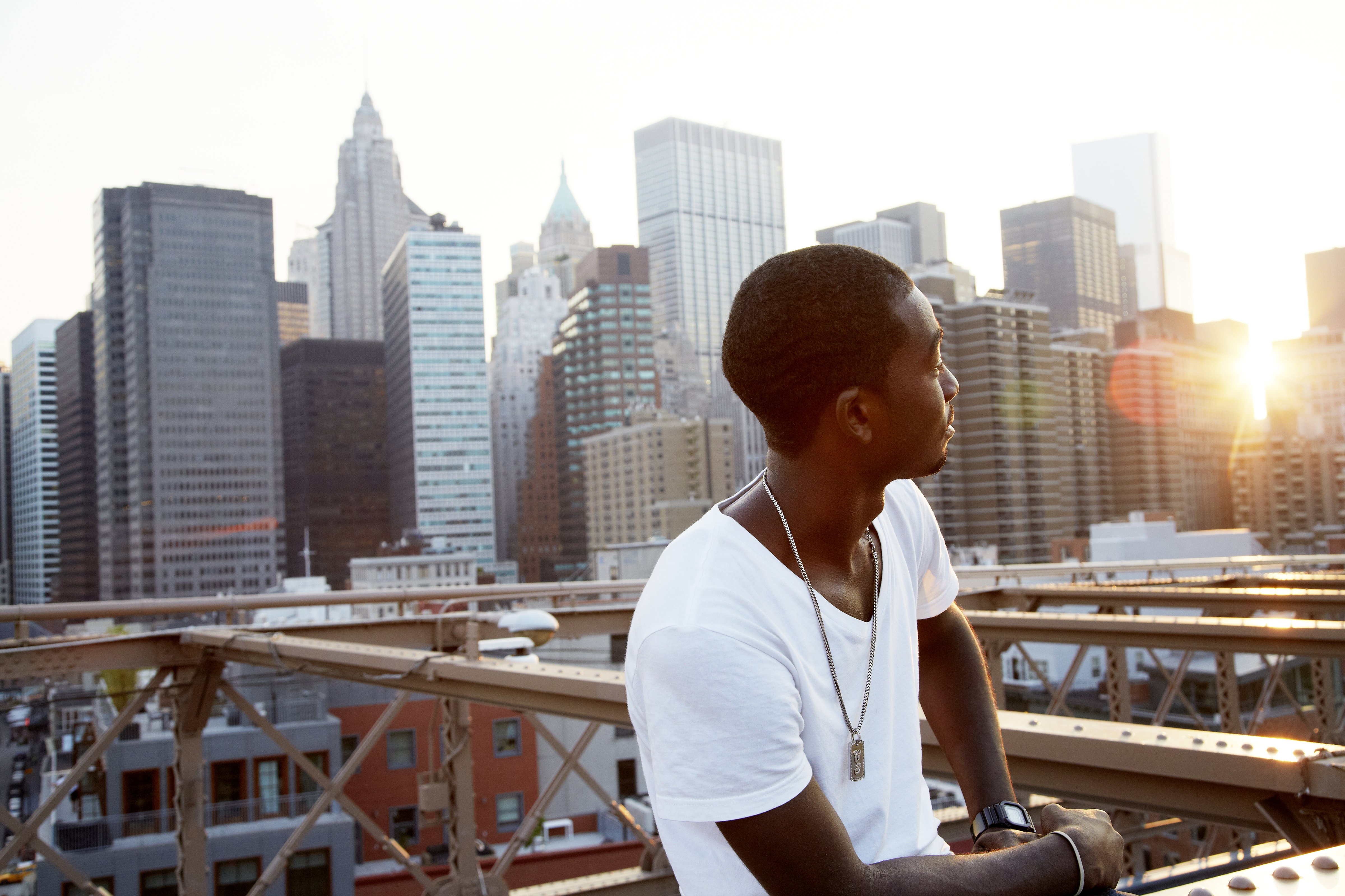 Young man on bridge with city skyline