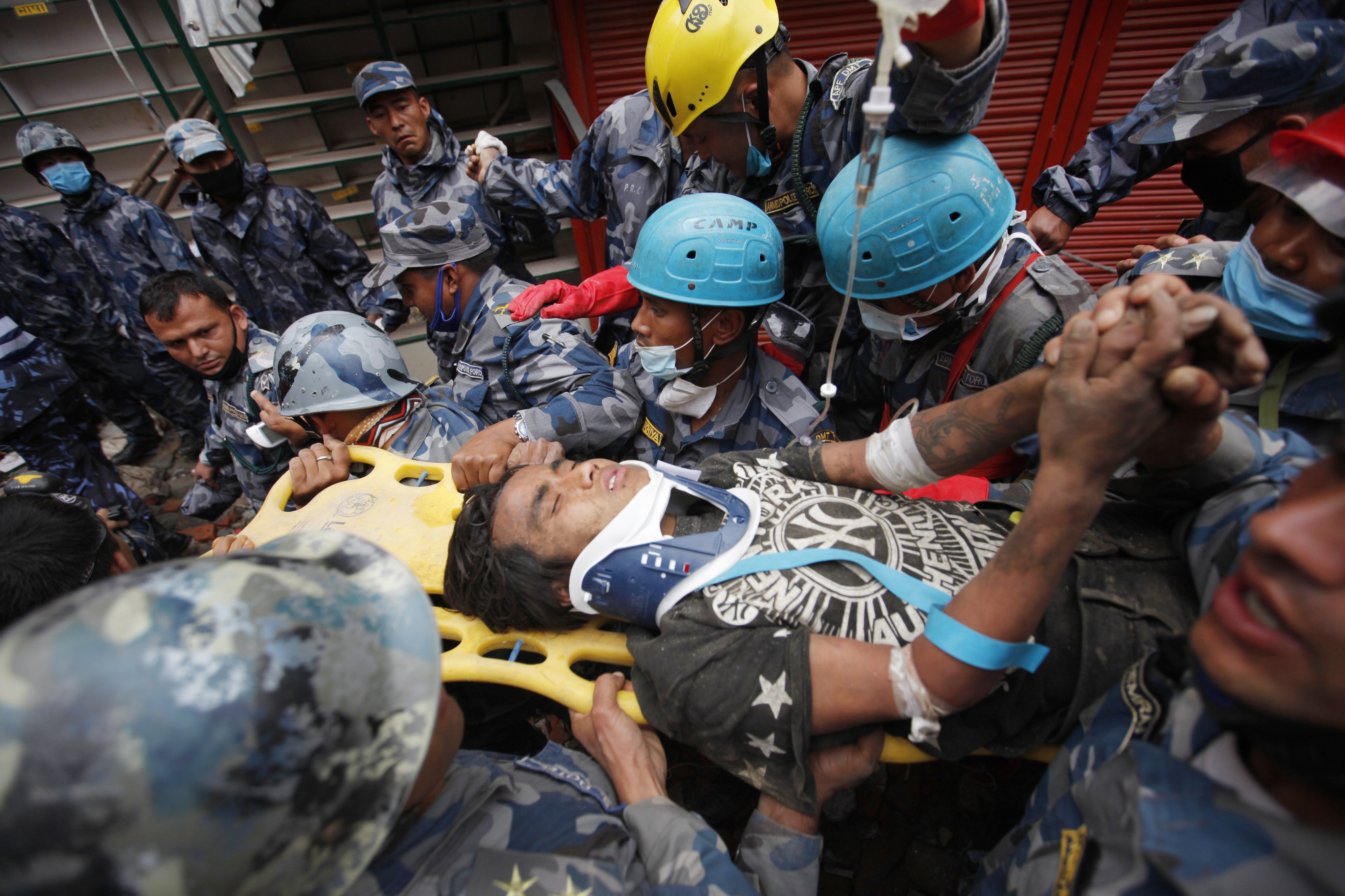 Pemba Tamang is carried on a stretcher after being rescued by Nepalese policemen and U.S. rescue workers from a building that collapsed five days ago in Kathmandu, Nepal on April 30, 2015.