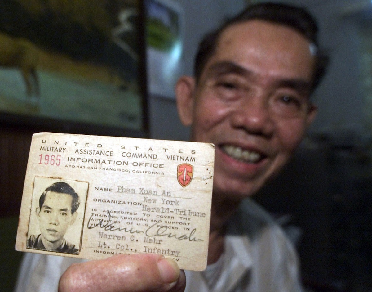 Pham Xuan An holds up his press card from 1965 at his home in Ho Chi Minh City, Vietnam, on April 26, 2000 (Charles Dharapak—AP)