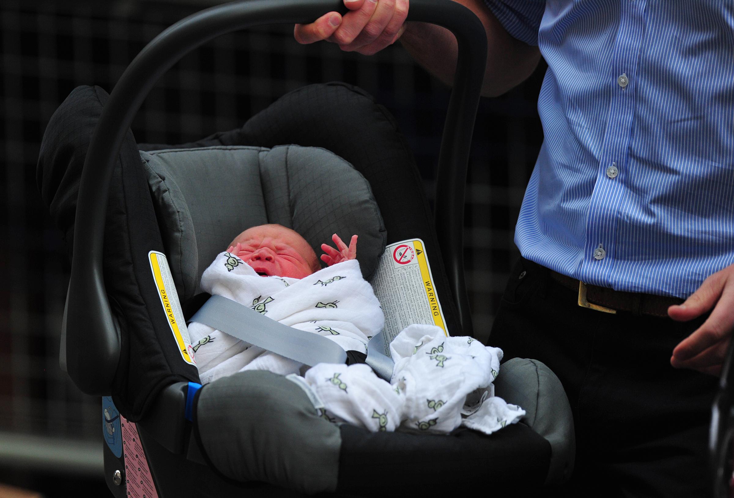 Prince William and Catherine, Duchess of Cambridge's new-born baby boy is introduced to the world's media outside the Lindo Wing of St Mary's Hospital in London on July 23, 2013. The baby was born on Monday afternoon weighing eight pounds six ounces (3.8 kilogrammes). The baby, titled His Royal Highness, Prince (name) of Cambridge, is directly in line to inherit the throne after Charles, Queen Elizabeth II's eldest son and heir, and his eldest son William. AFP PHOTO / CARL COURT (Photo credit should read CARL COURT/AFP/Getty Images)