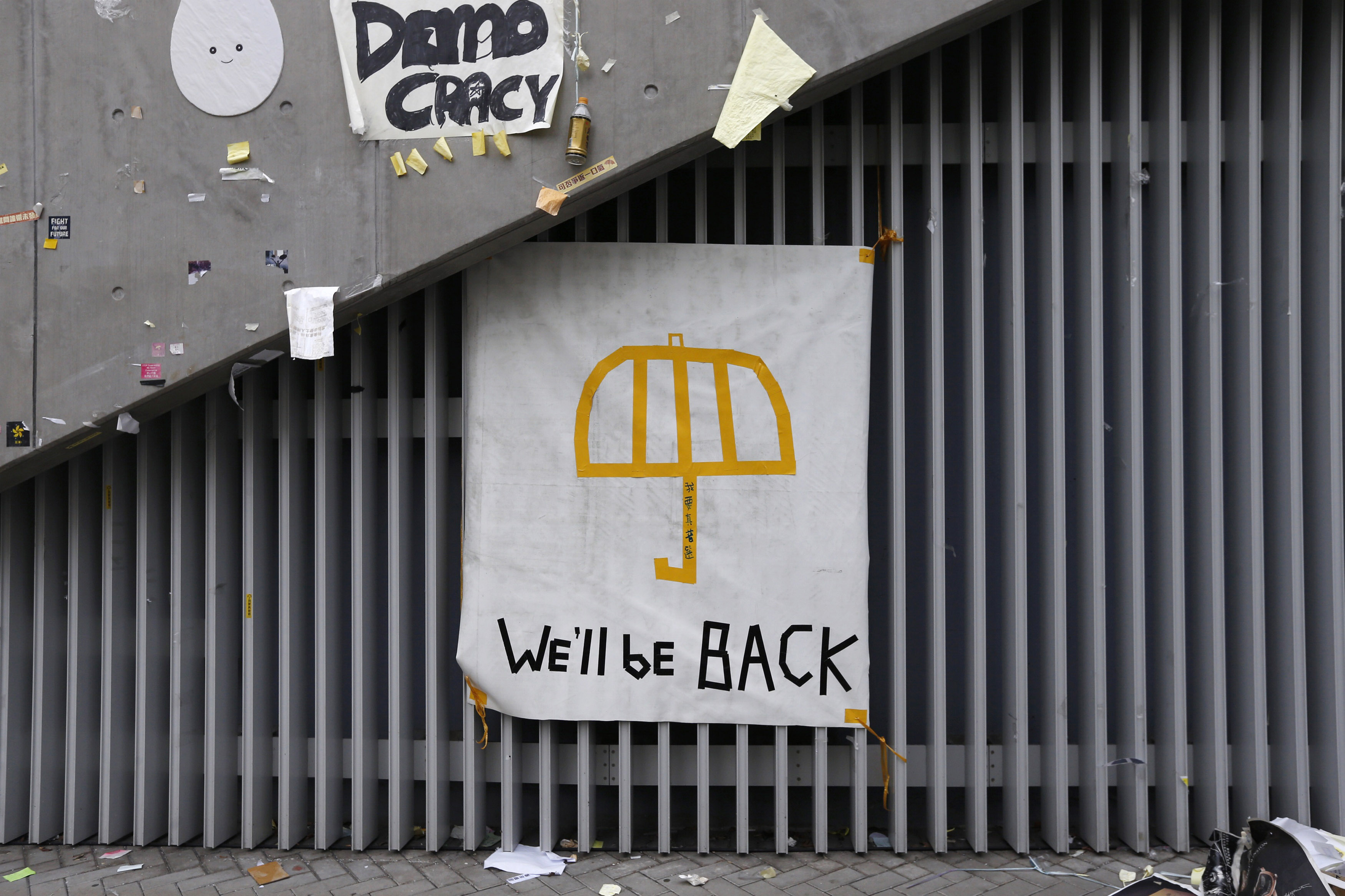 A poster of an umbrella with the words "We'll be back" written underneath is pictured on a wall at the main "Occupy" protest site at Admiralty in Hong Kong