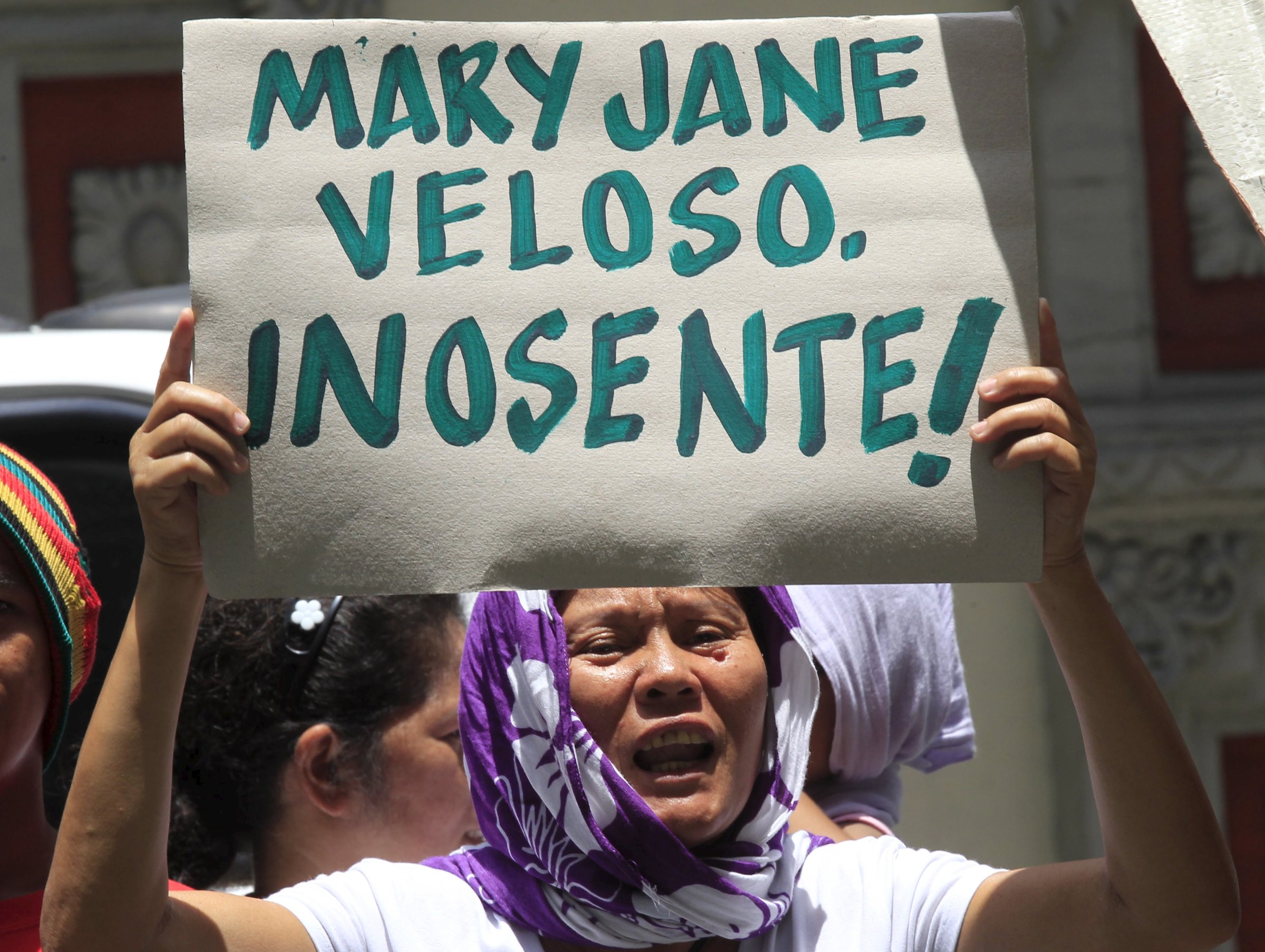 A protester holds a placard urging the Philippine and Indonesian government to save Mary Jane Veloso, a Filipina facing execution in Indonesia, during a protest in front of the Indonesian embassy in Makati city