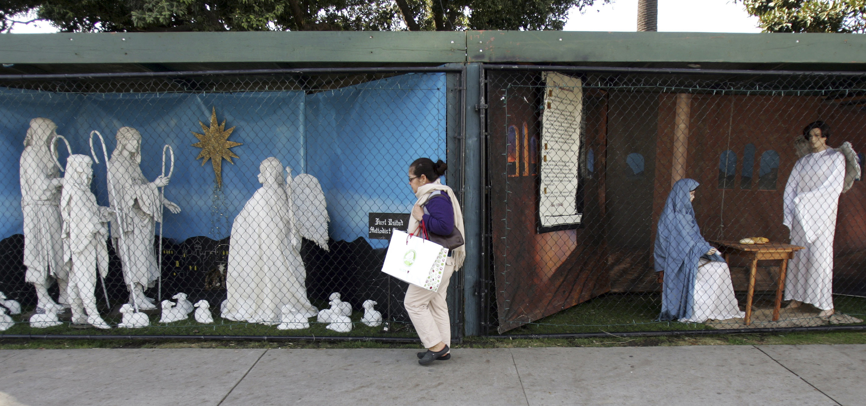 In this Dec. 13, 2011 file photo, a woman walks past a two of the traditional displays showing the Nativity scene along Ocean Avenue at Palisades Park in Santa Monica, Calif. (Ringo H.W. Chiu—AP)