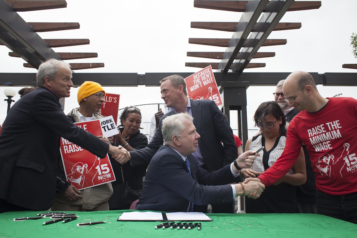 Seattle Mayor Ed Murray (C) celebrates with supporters aafter signing a bill that raises the city's minimum wage to $15 an hour on June 3, 2014, in Seattle (David Ryder—Getty Images)