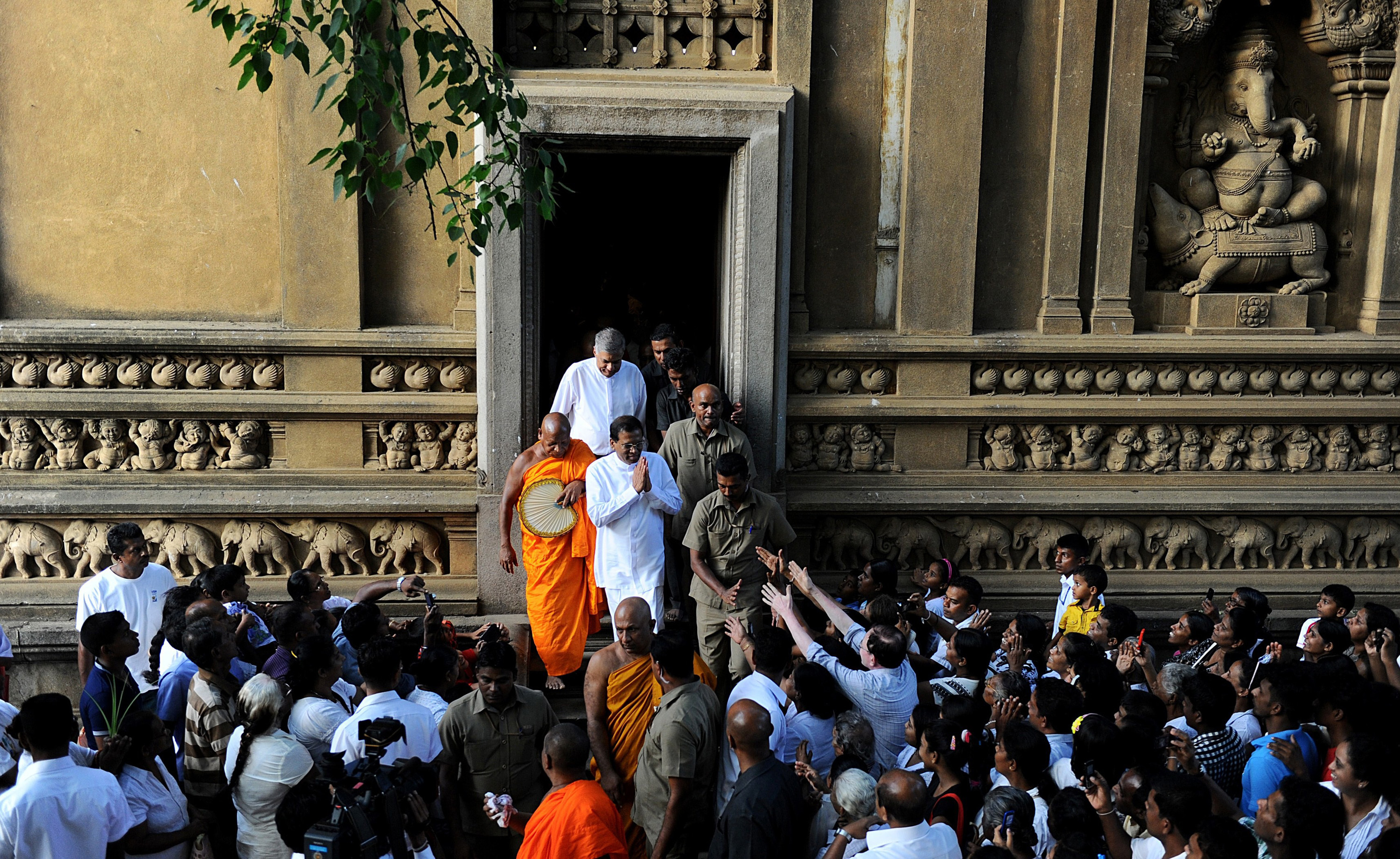 Sirisena, in white with hands together, greets his supporters after praying at a Buddhist temple outside Colombo. (Ishara S. Kodikara—AFP/Getty Images)