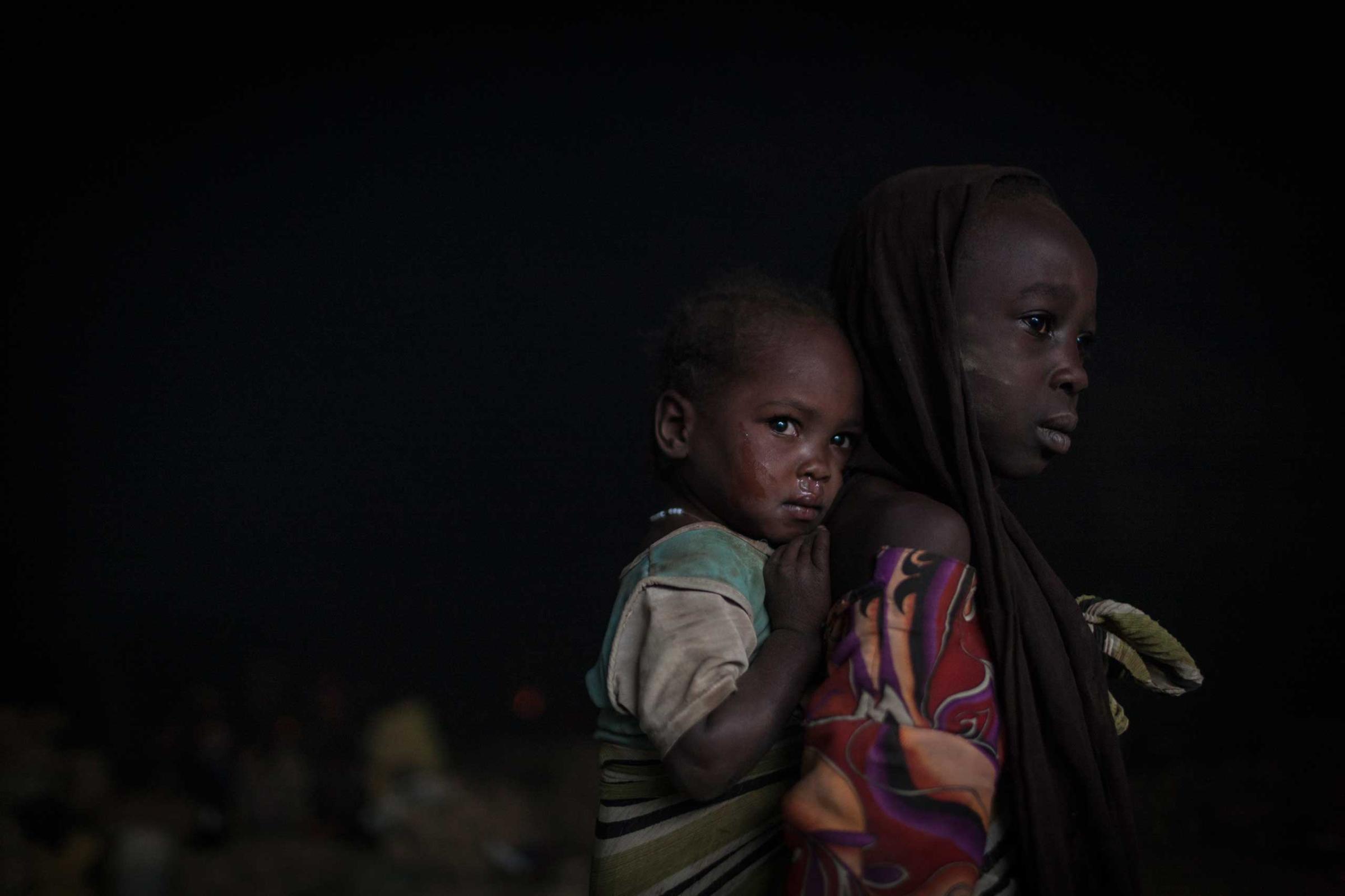 In the early morning, sisters wake up in a cave where they sleep with hundreds of other people whose villages have been destroyed, or who are seeking shelter from bombardment, outside Sarong in Central Darfur, Sudan, March 2, 2015.