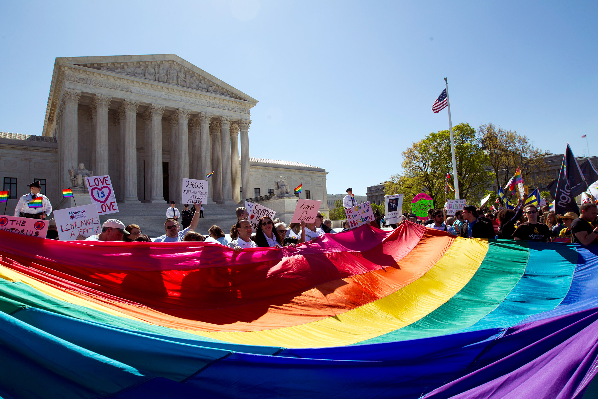 Demonstrators stand in front of a rainbow flag of the Supreme Court in Washington on April 28, 2015. (Jose Luis Magana—AP)
