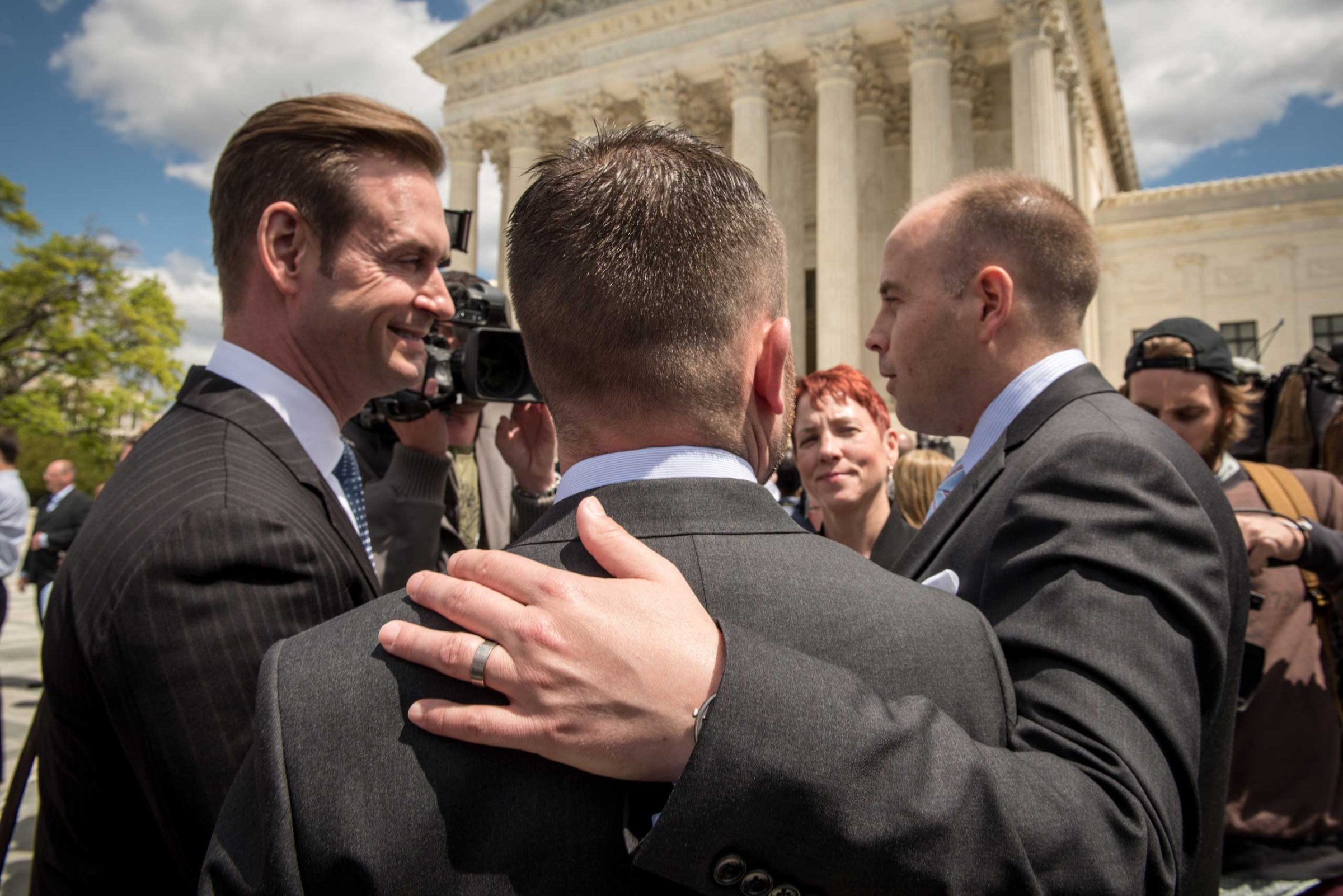 Plaintiffs Thomas Kostra, center and his husband Ijpe Dekoe, right, from Tennessee, speak with the media outside the Supreme Court of the United States following arguments on marriage equality in Washington on April 28, 2015.