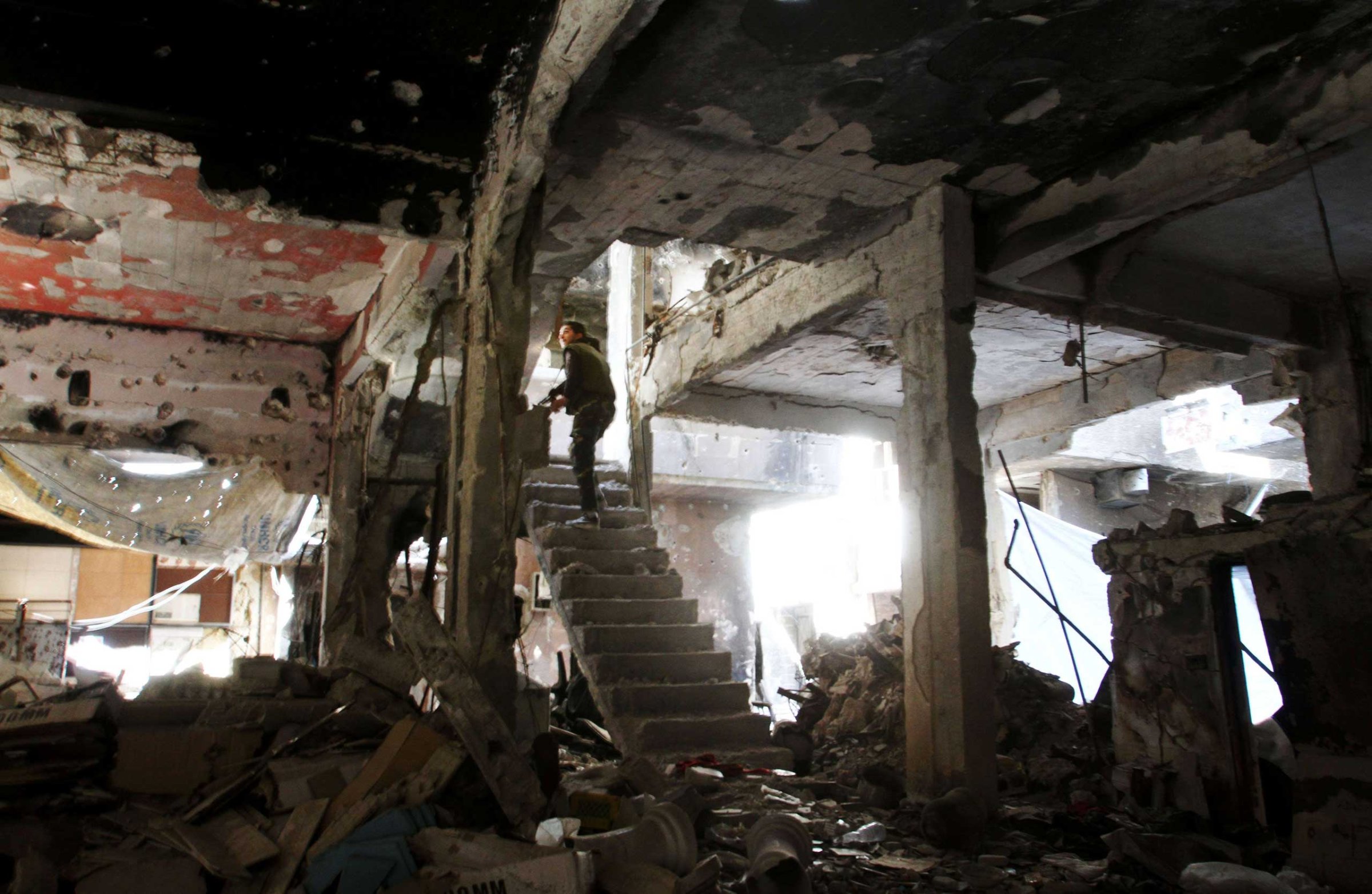 A man stands on a staircase inside a demolished building in the Yarmuk Palestinian refugee camp in the Syrian capital Damascus on April 6, 2015.